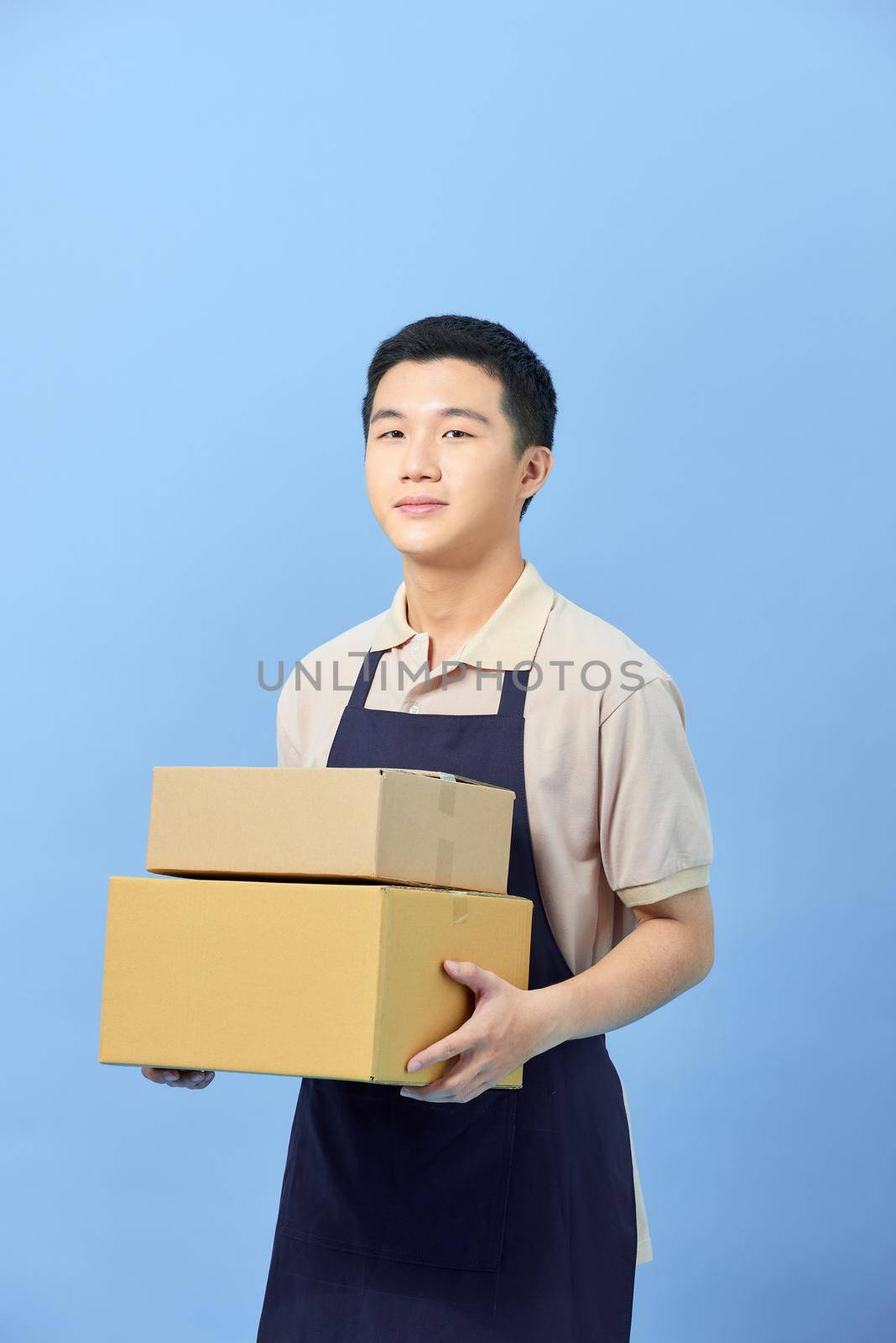 Asian smart handsome male holding boxes for delivery to customers by makidotvn