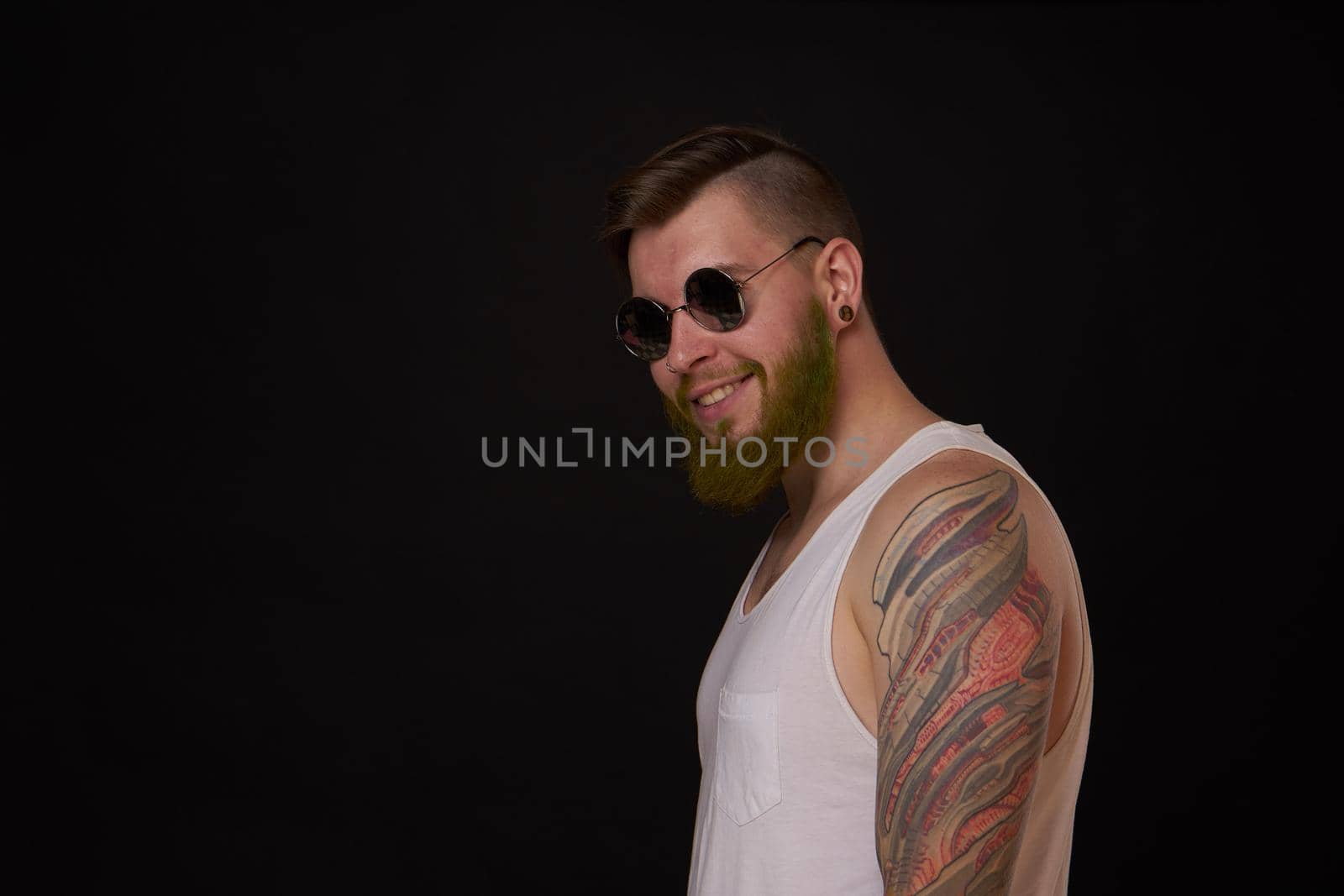 bearded macho man in white t-shirt sunglasses fashion tattoos. High quality photo