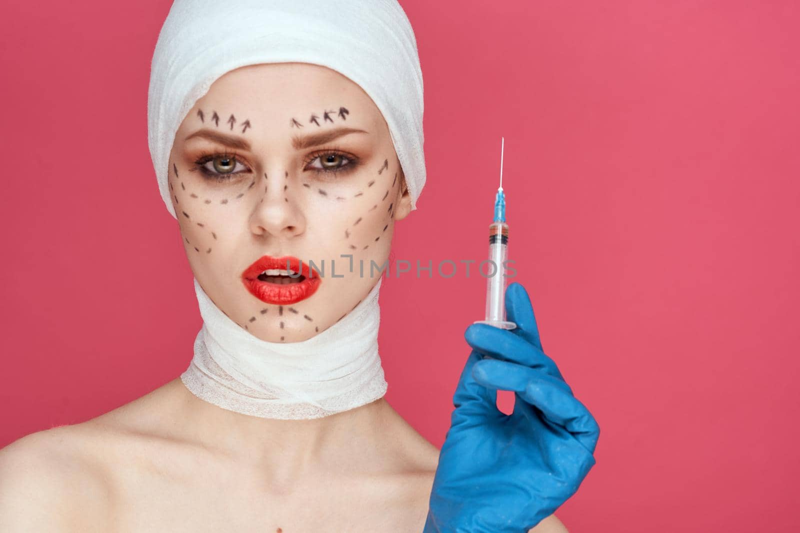 woman posing in blue gloves red lips surgery facial rejuvenation pink background. High quality photo