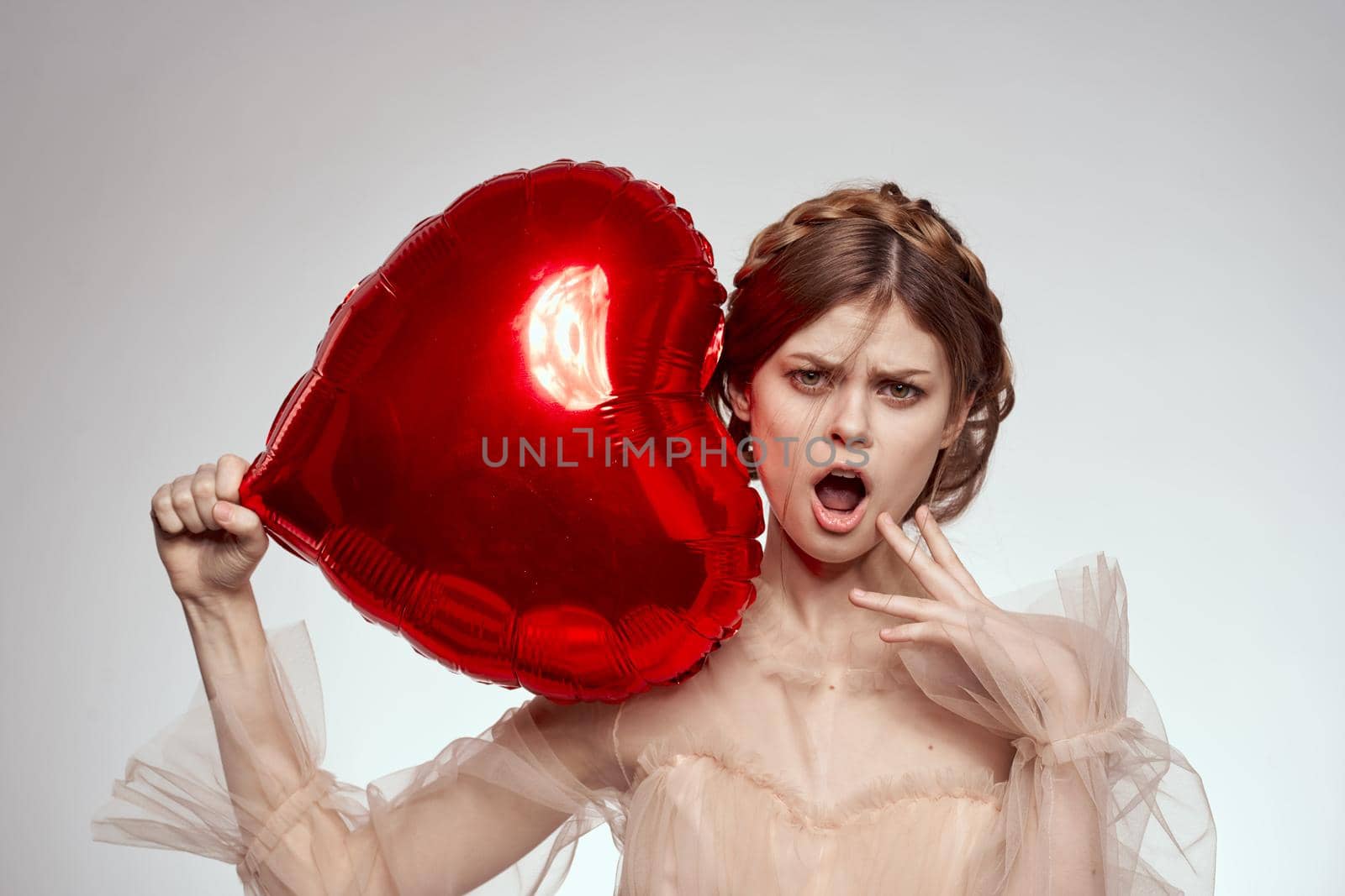 portrait of a woman Birthday party gift heart balloon light background. High quality photo