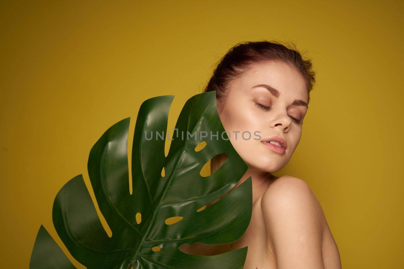 attractive woman clean skin palm leaf cosmetics spa treatments. High quality photo