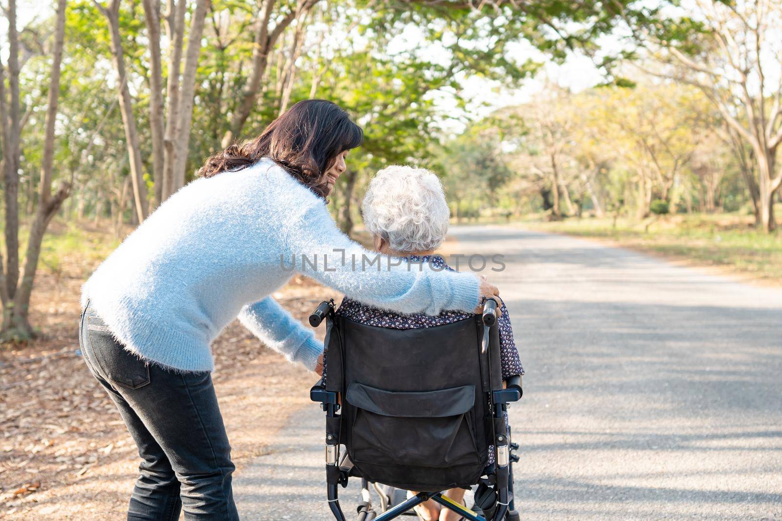 Asian senior or elderly old lady woman patient with care, help and support on wheelchair in park in holiday, healthy strong medical concept. by pamai