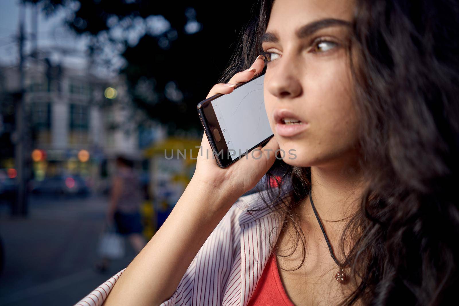 woman talking on the phone outdoors walking in the evening on the street. High quality photo