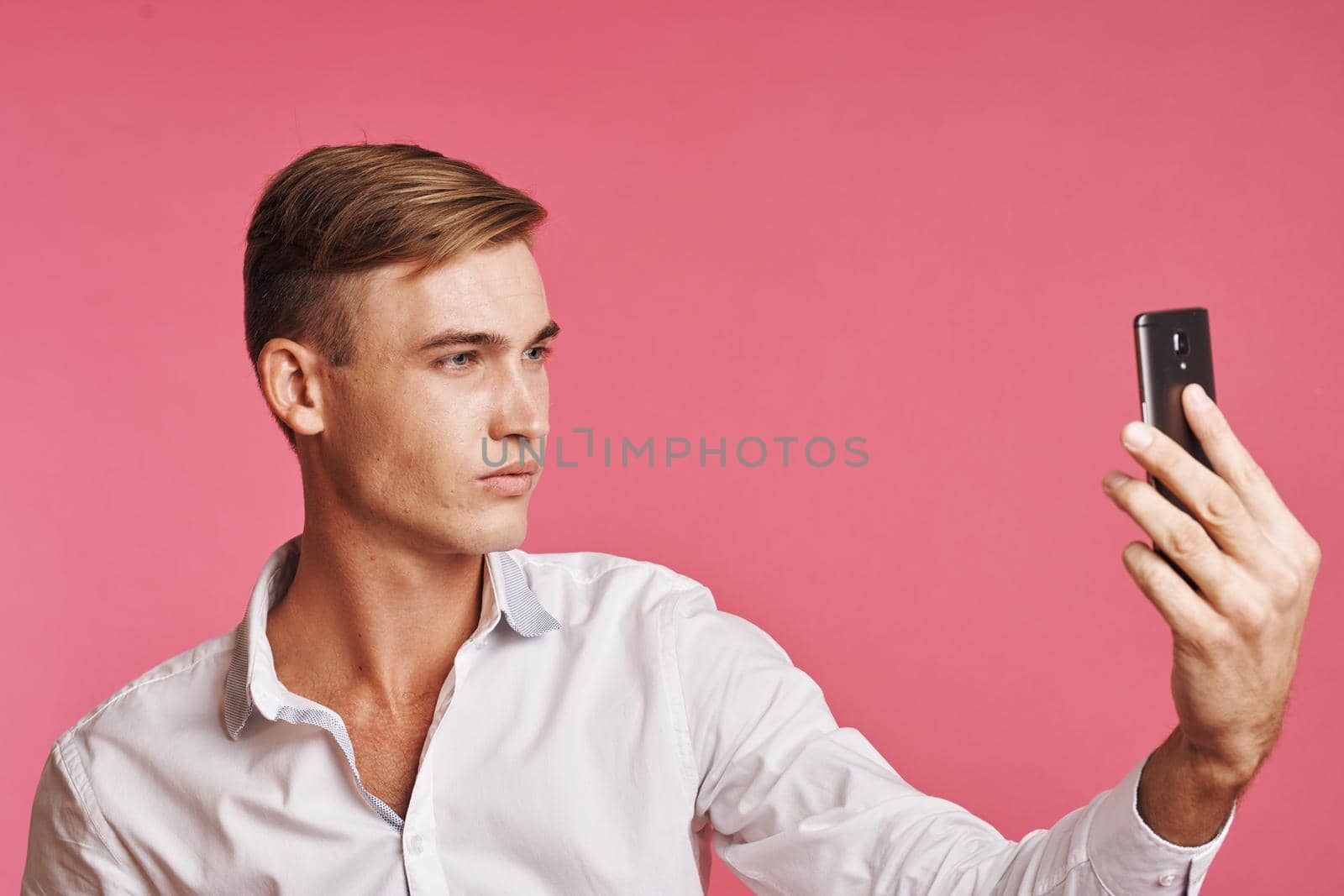 handsome man with a phone in hand fashion posing isolated background by Vichizh