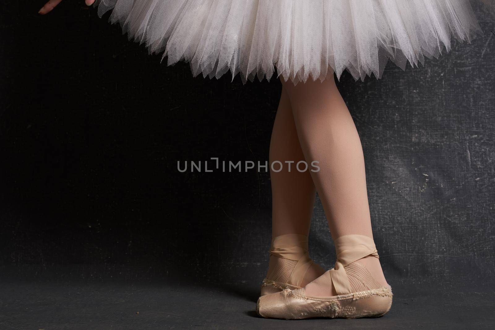 crossed legs ballerinas ballet shoes performance dark background. High quality photo