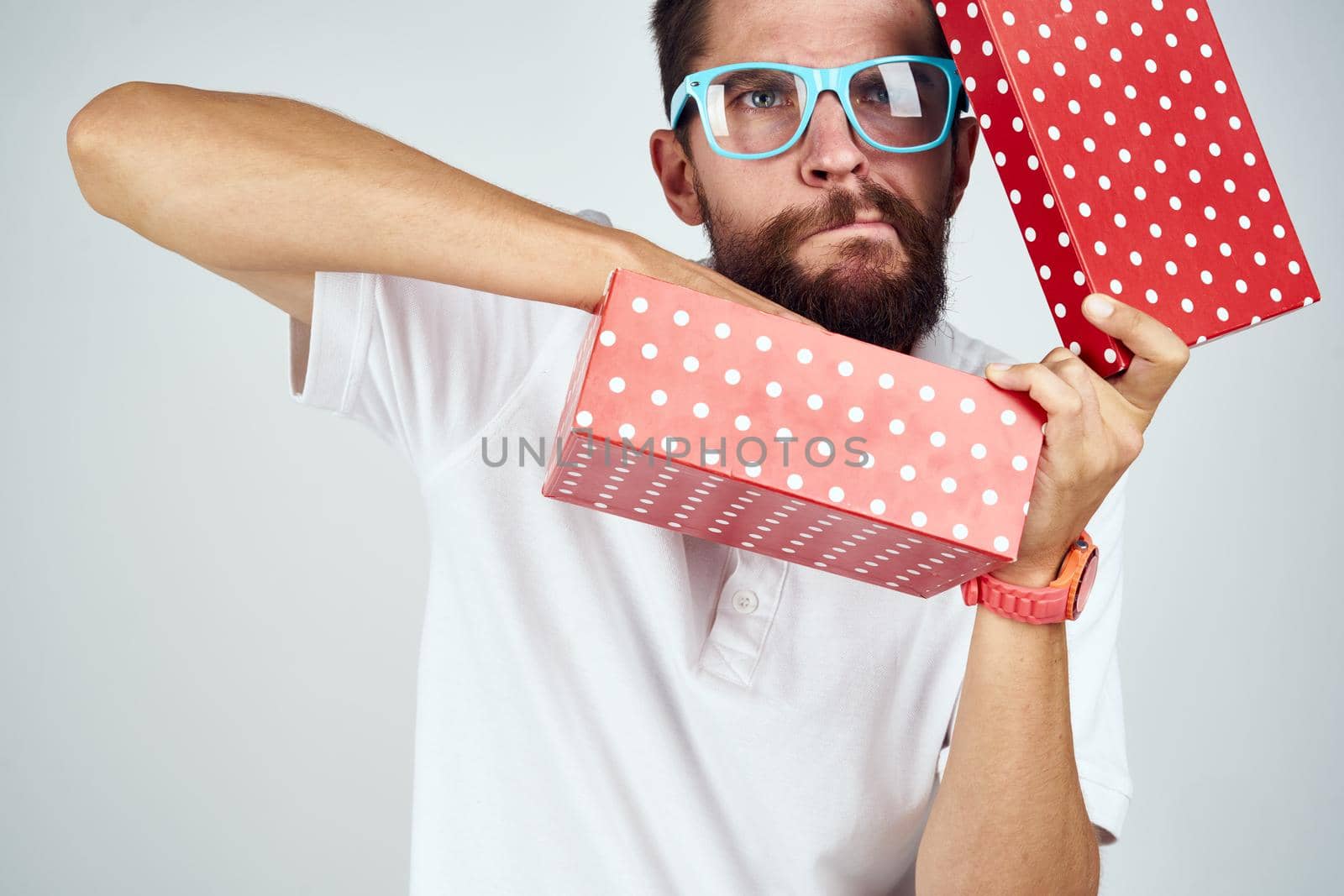 man with gift box wearing glasses holiday fun light background. High quality photo