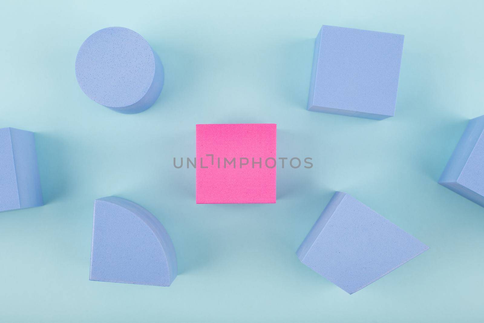 Concept of individuality and being different from others in blue colors. Pink cube and blue geometric figures on bright background by Senorina_Irina