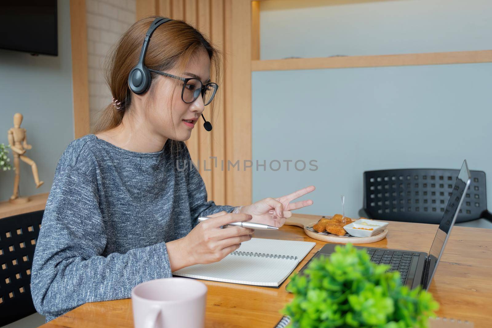 Asian woman wear headphones look at laptop enjoy study online with tutor, listen audio lecture watch webinar prepare for exams, e-learn, self education concept.