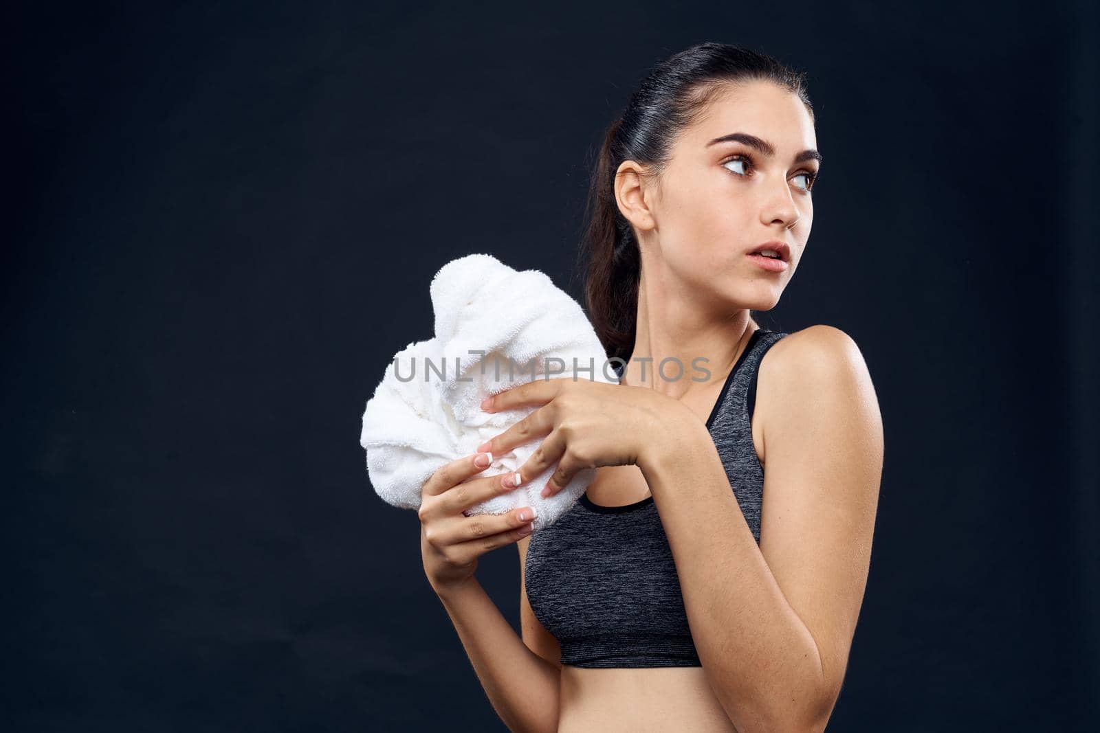 athletic woman with white towel gym slim figure dark background. High quality photo