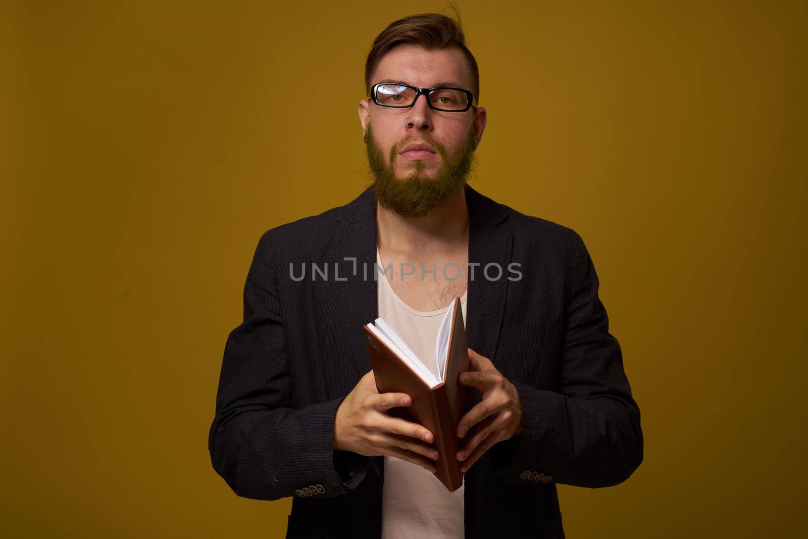 bearded man in a black jacket with a book in his hands education. High quality photo