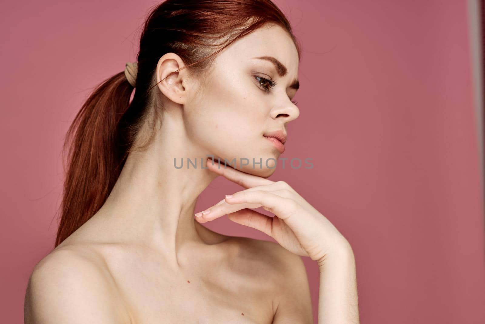 woman with bare shoulders charm cosmetics pink background posing by Vichizh