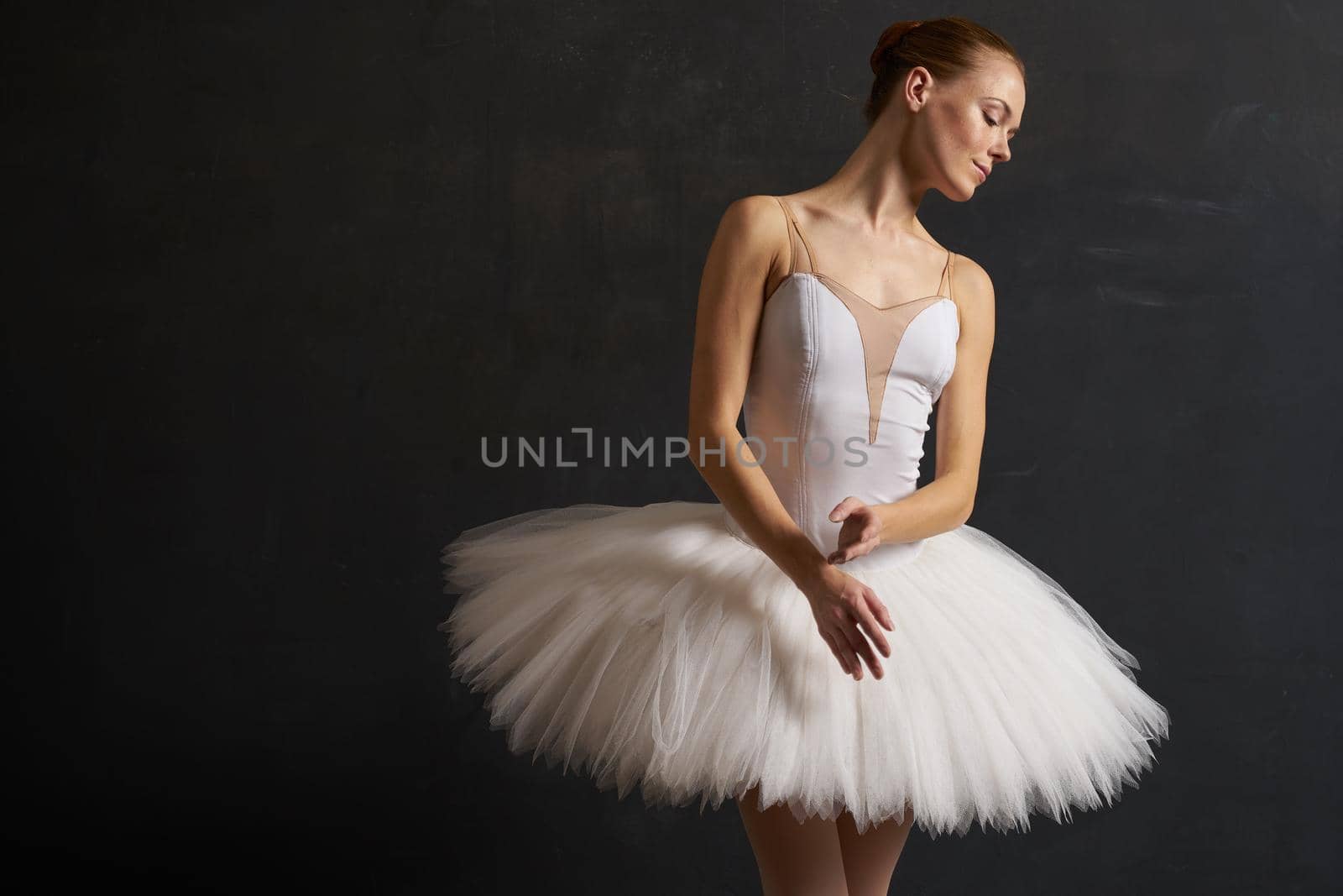 ballerina in a white tutu dance performance silhouette dark background. High quality photo