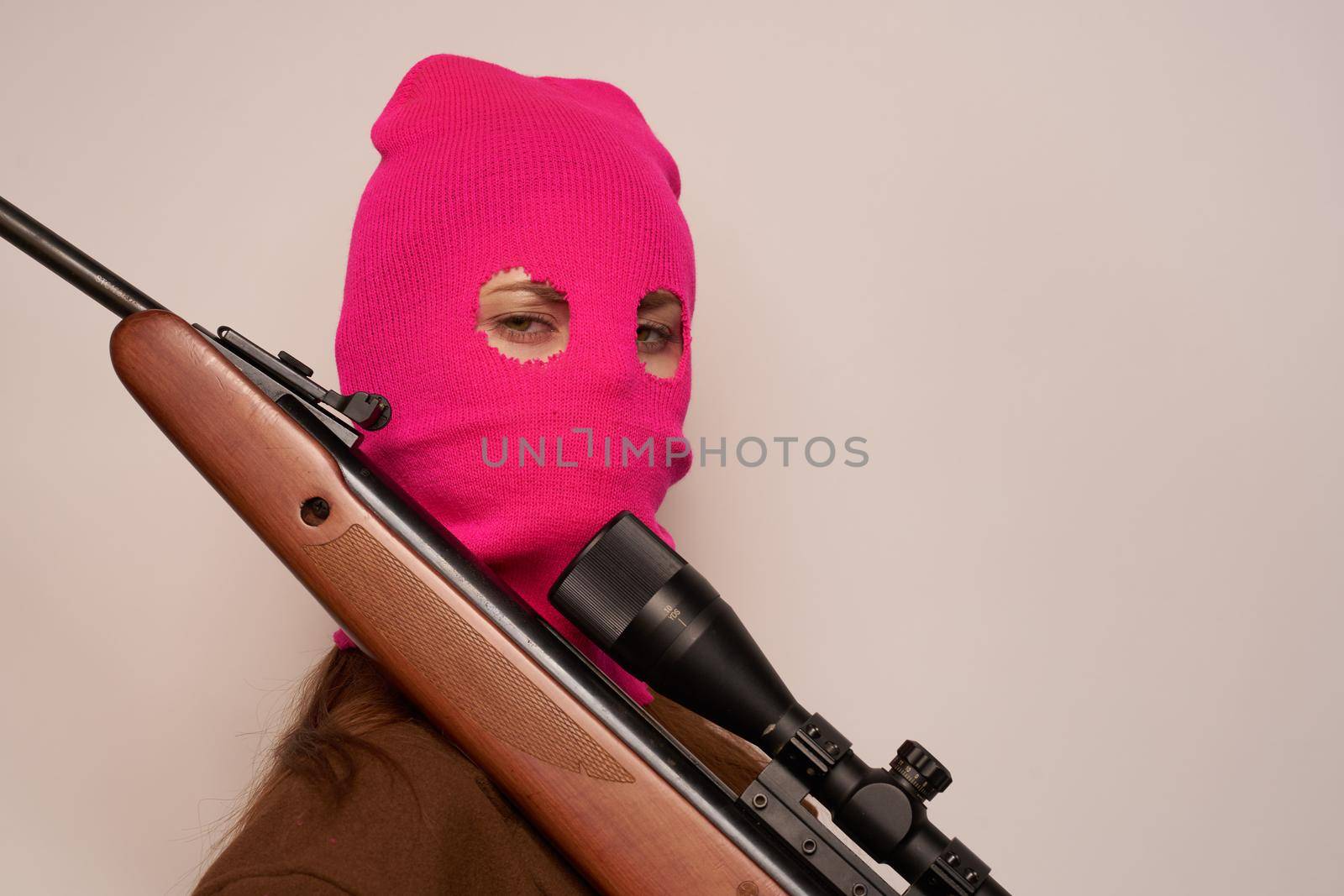 woman gangster with a gun in hand Lifestyle beige background. High quality photo