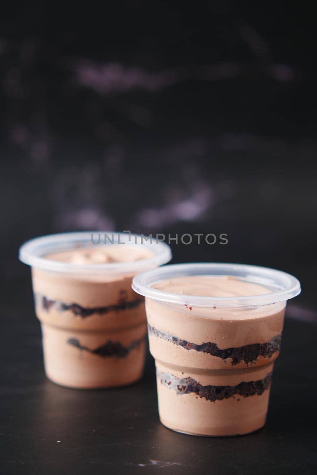 Mousse cake in a container on black background by towfiq007