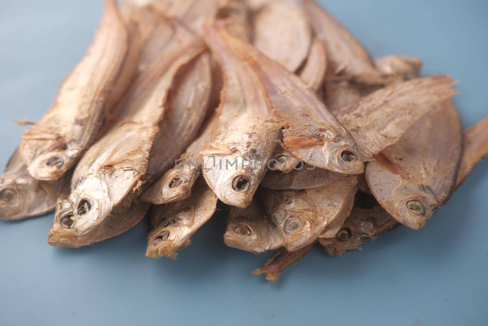 close up of dried fish on blue backgrund .