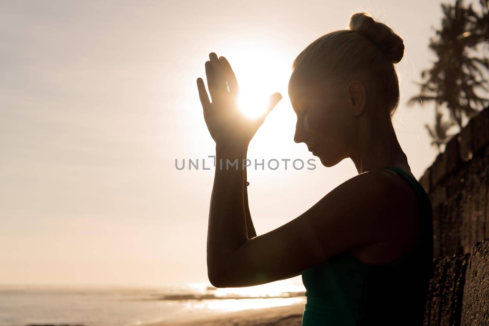 beautiful woman meditating outdoors on the beach. bali