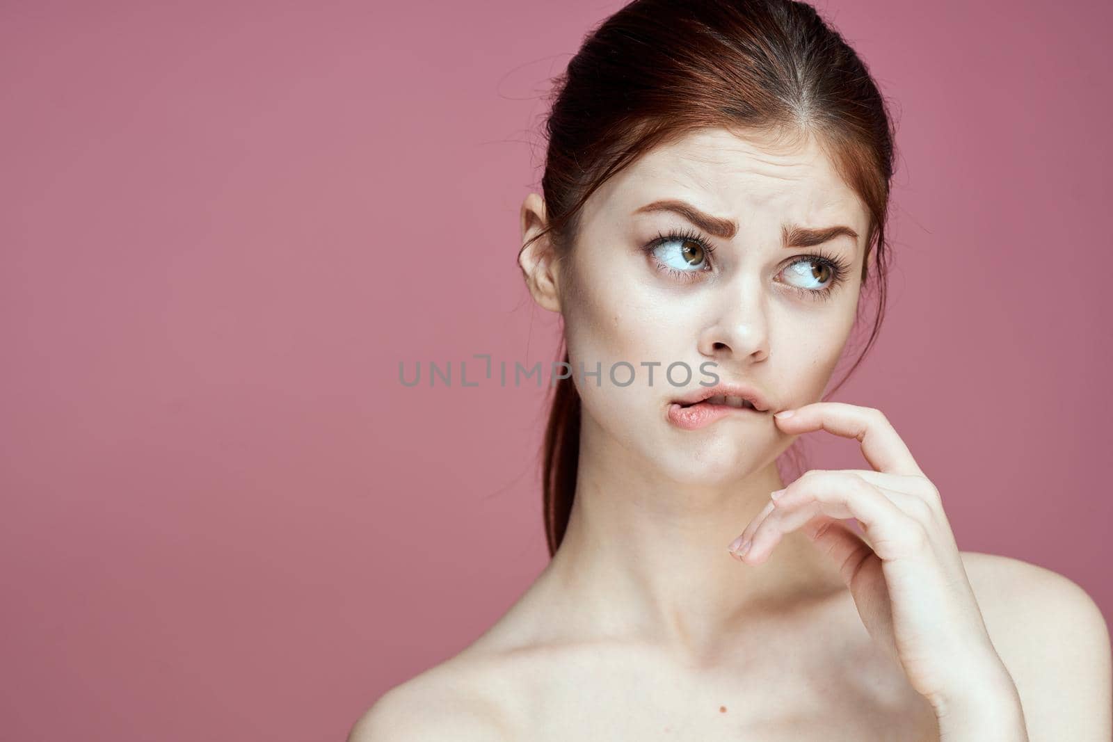 woman with bare shoulders charm cosmetics pink background posing. High quality photo