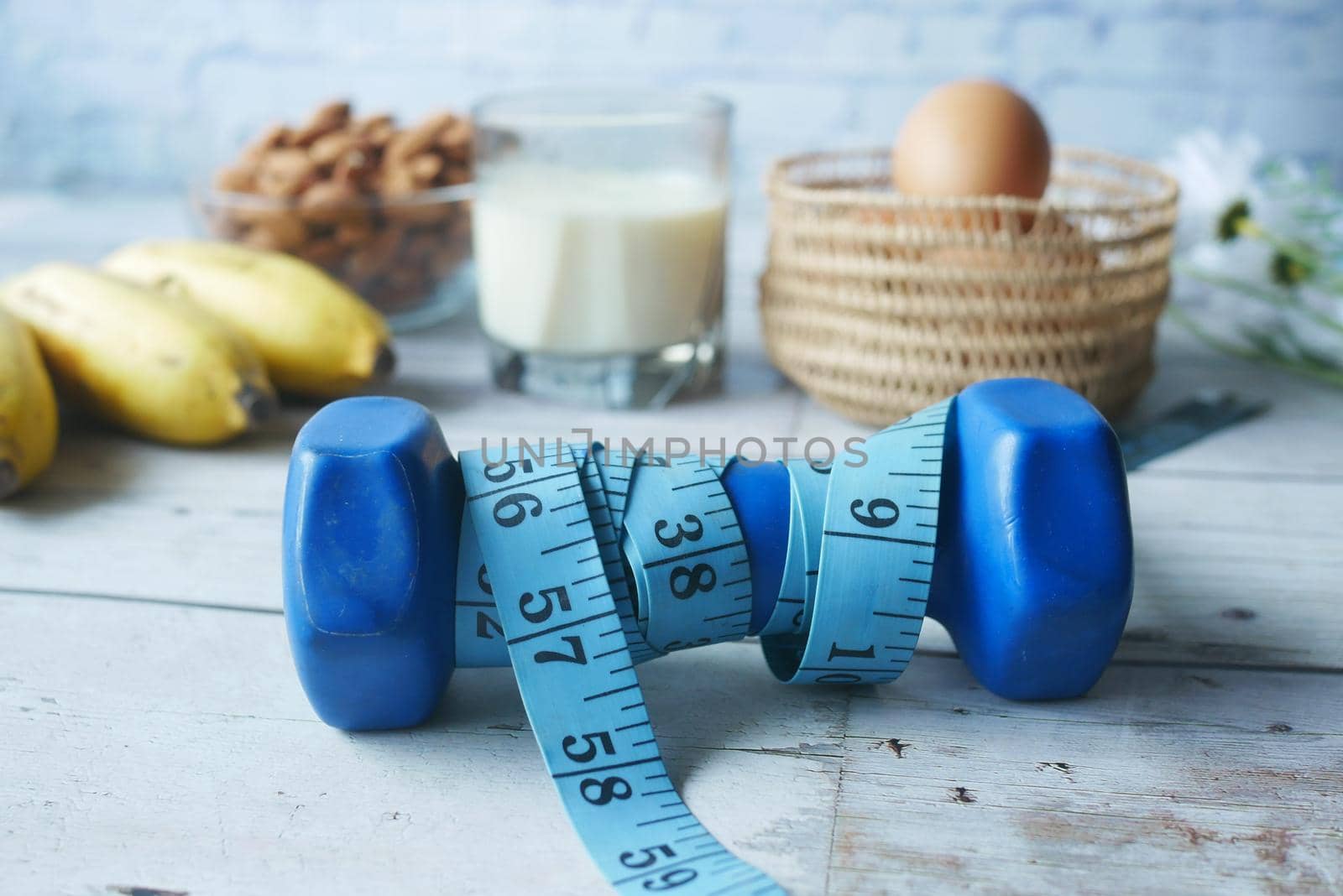 Diet plan with almond nut, dumbbells, banana on table.