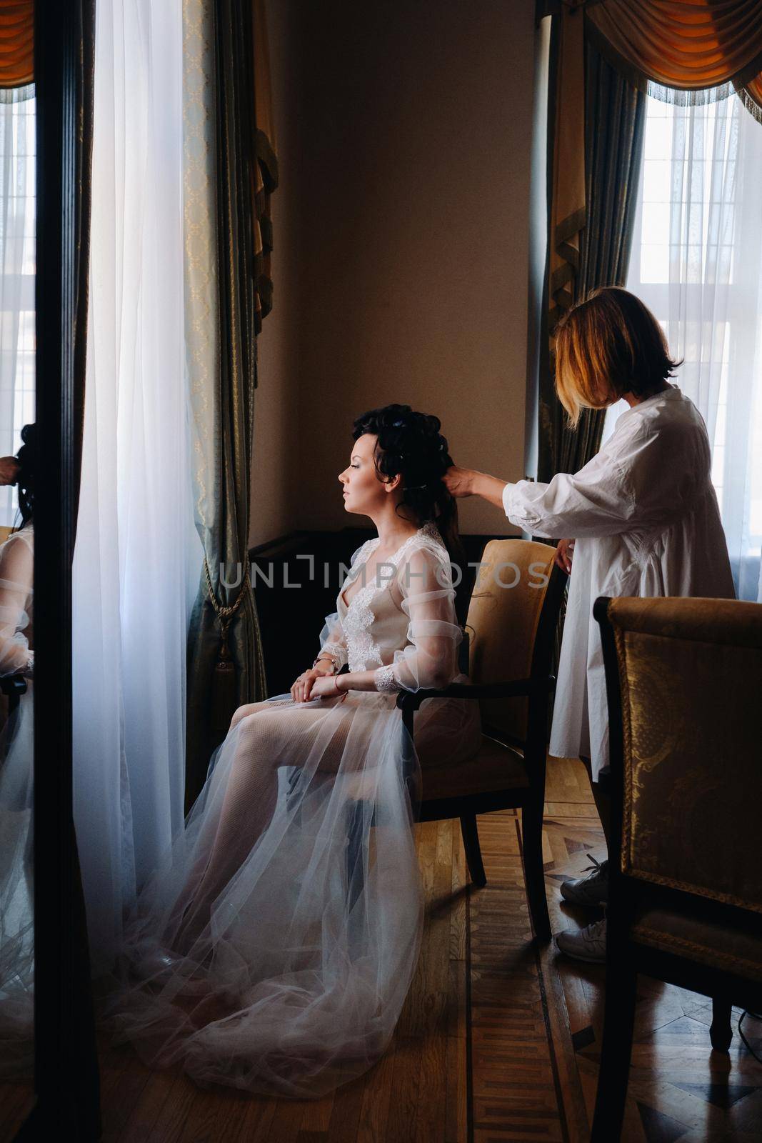 The hairdresser does the bride's hairstyle.Morning of the bride.