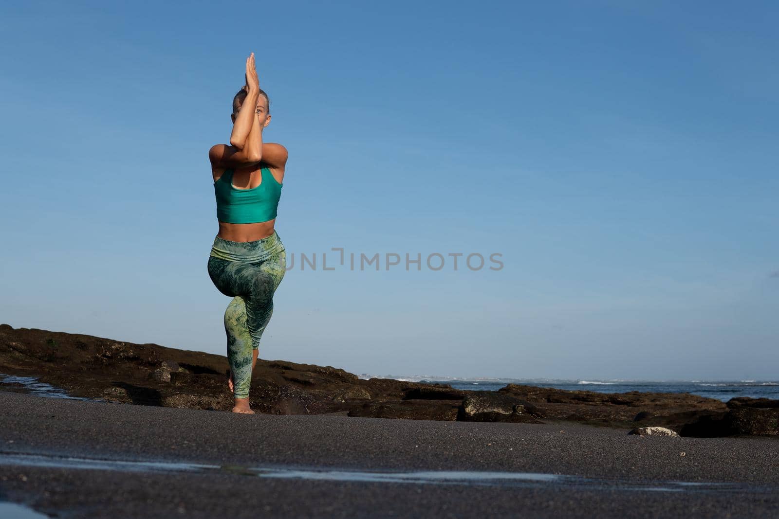 beautiful woman doing yoga on the beach. bali