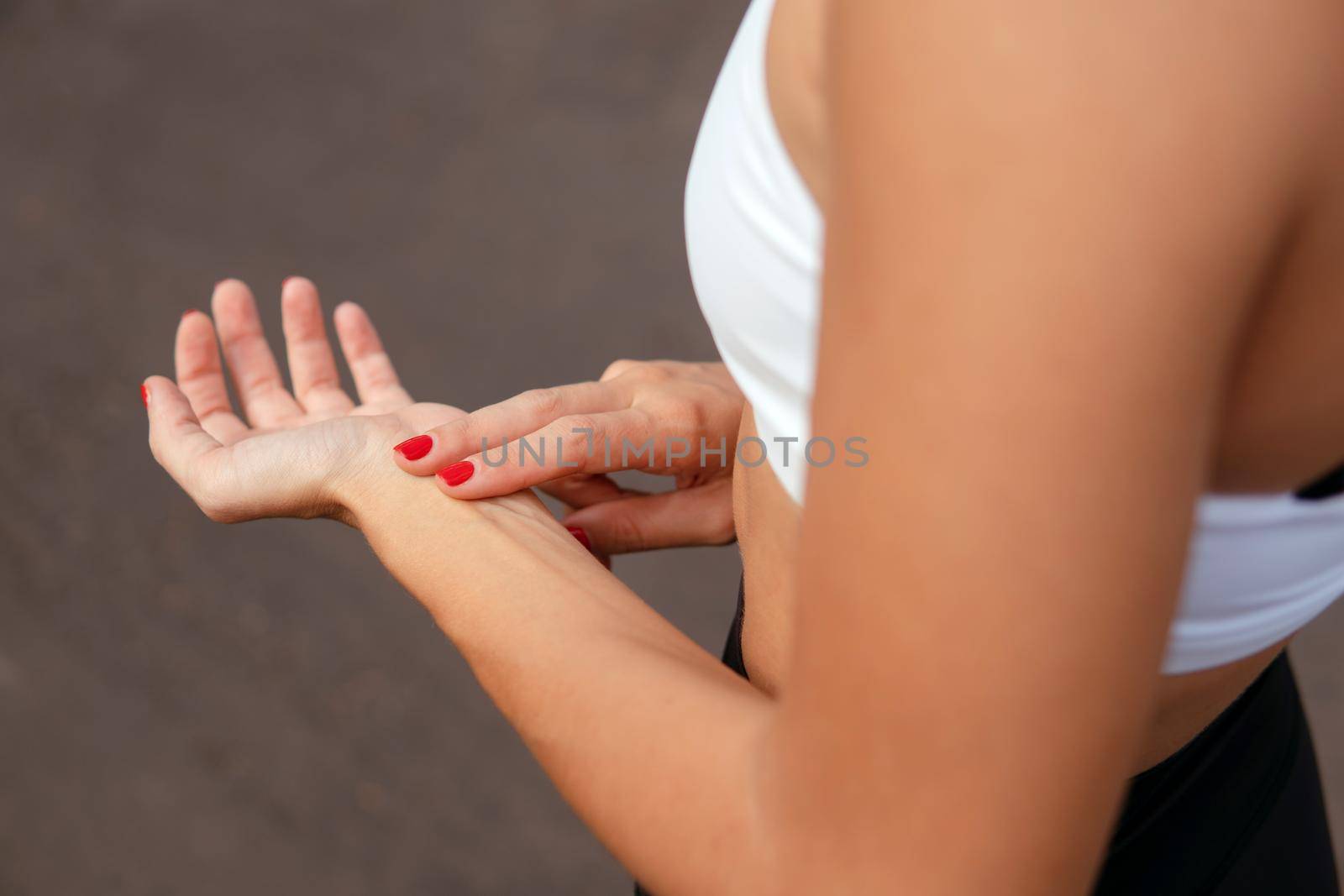 Woman checking pulse. Hand close-up. by Alexzhilkin