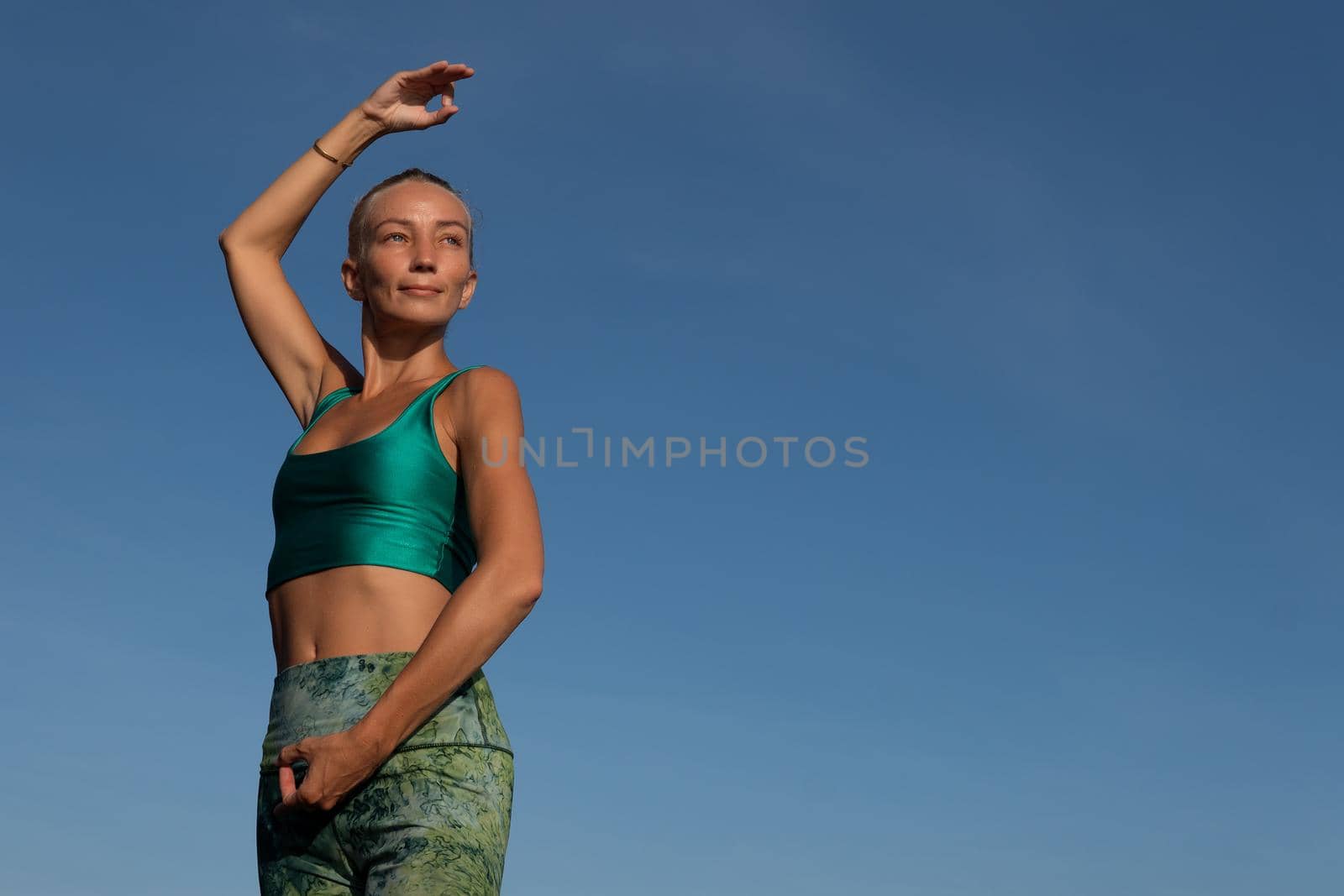 beautiful woman doing yoga on the beach by Alexzhilkin