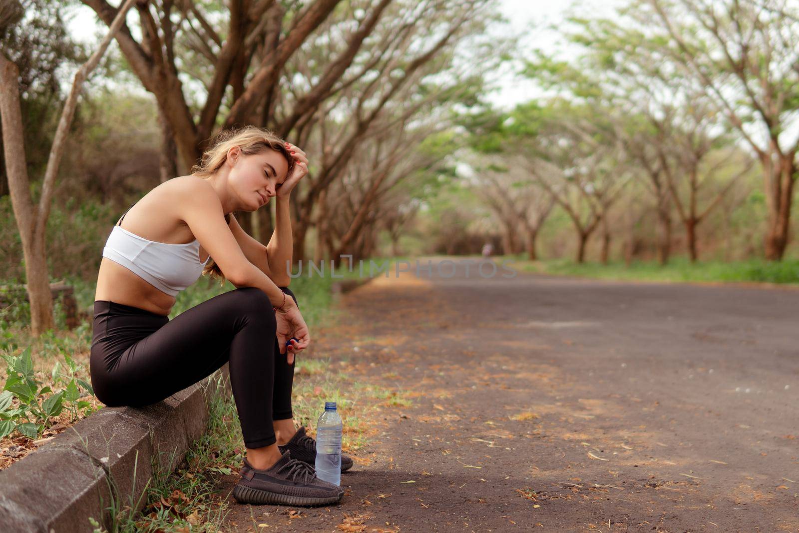 Woman in sportwear tired after running by Alexzhilkin