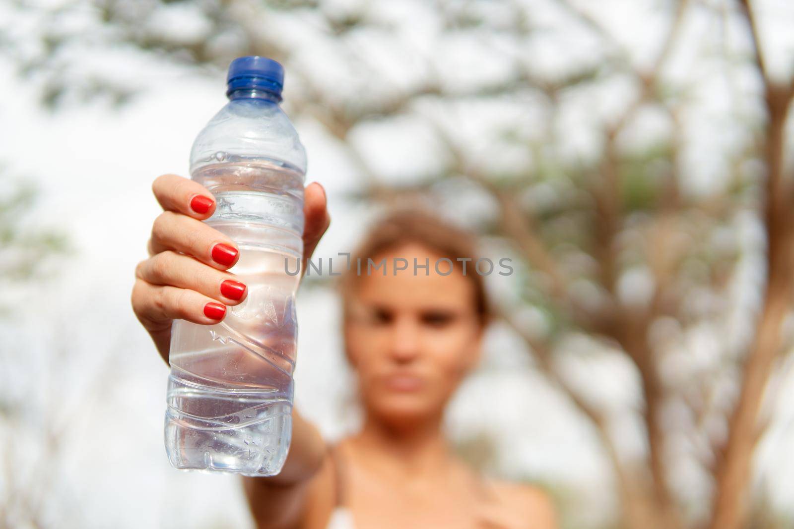 Woman warm up with bottle of water by Alexzhilkin