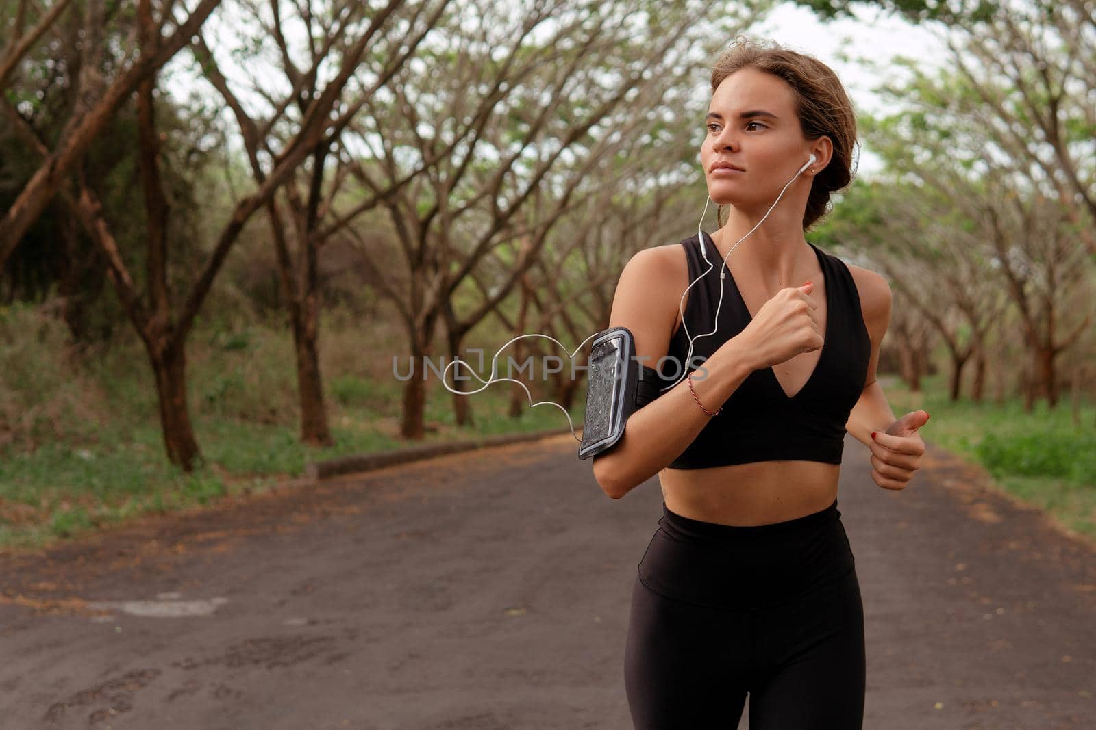 Beautiful girl go in for sports in black sportwear. autumn by Alexzhilkin