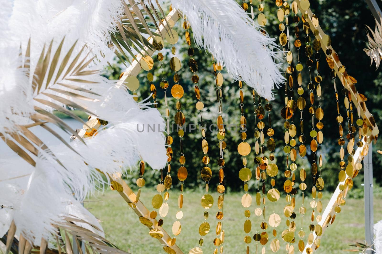 Decorated wedding arch in nature.Wedding ceremony with an arch decorated with feathers in retro style.