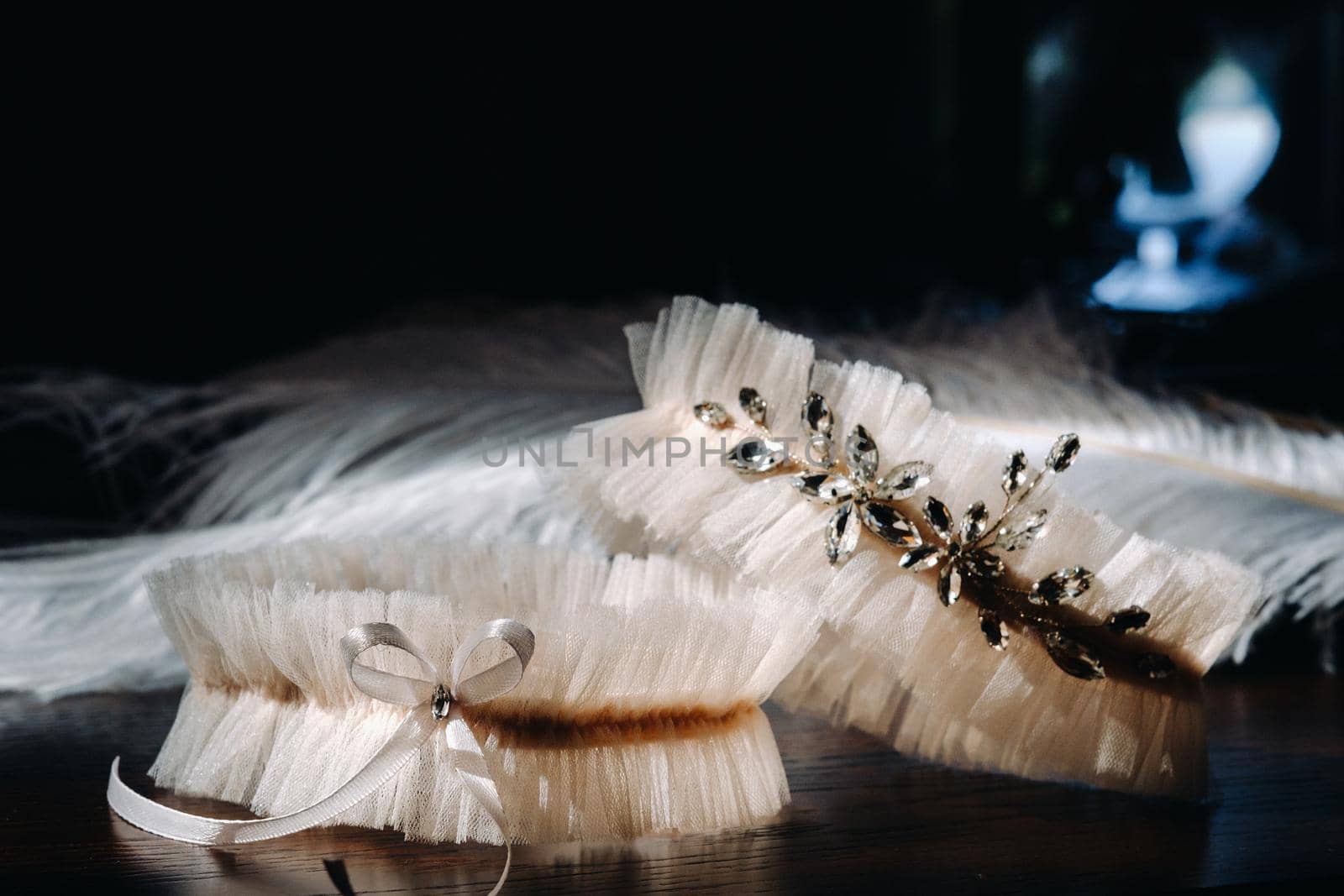 Two white garters of the bride are lying on the table.