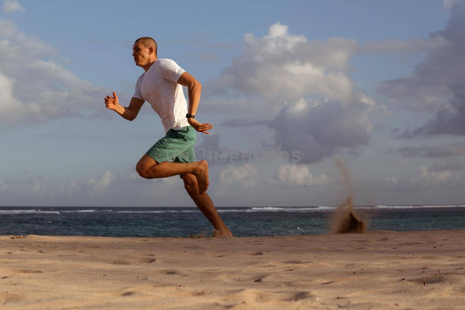 man doing sports on the beach by Alexzhilkin