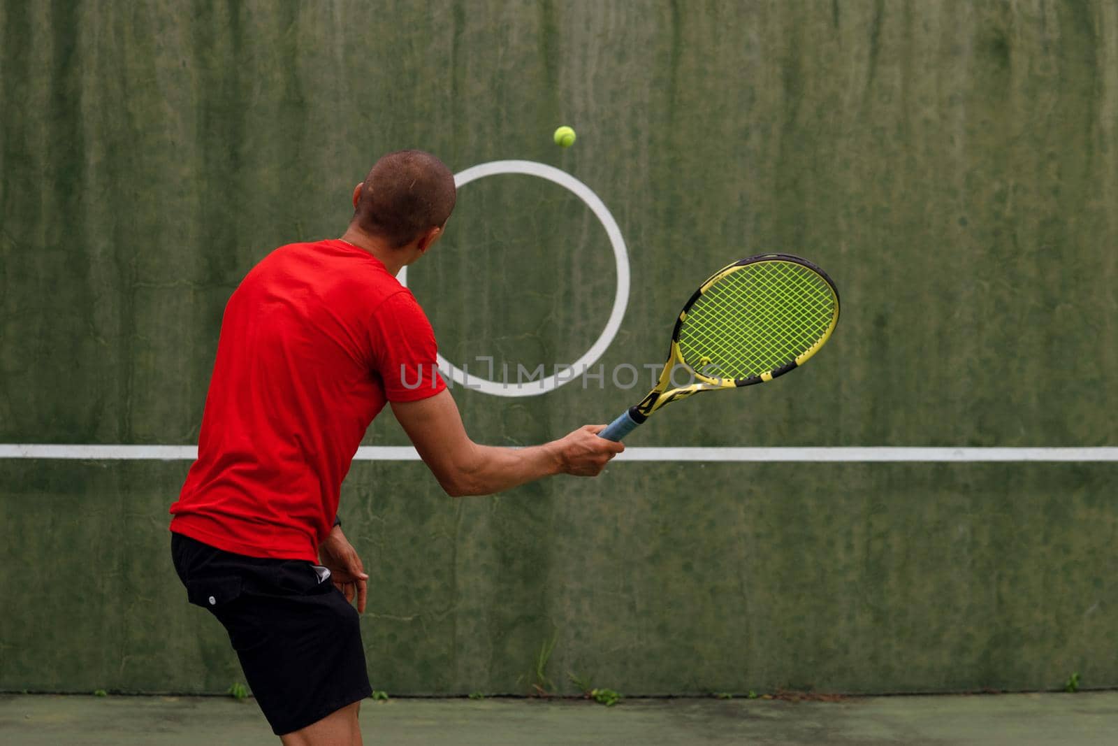 man in red sportwear playing tennis by Alexzhilkin