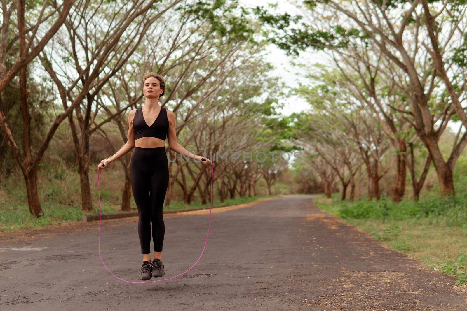 woman jumping rope in black sportwear. bali