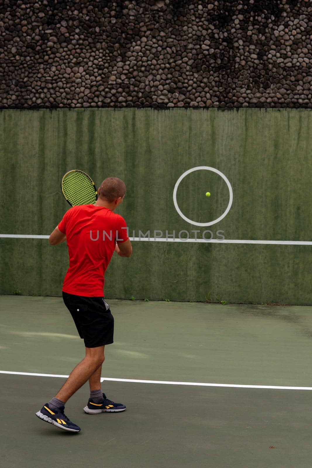 man in red sportwear playing tennis by Alexzhilkin