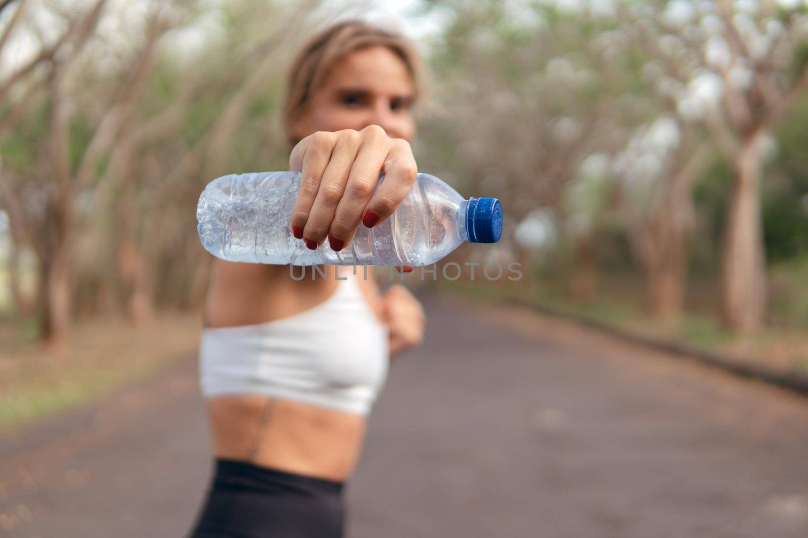 Woman warm up with bottle of water by Alexzhilkin