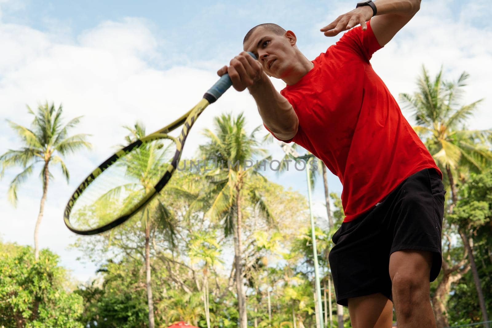 man in red sportwear playing tennis by Alexzhilkin