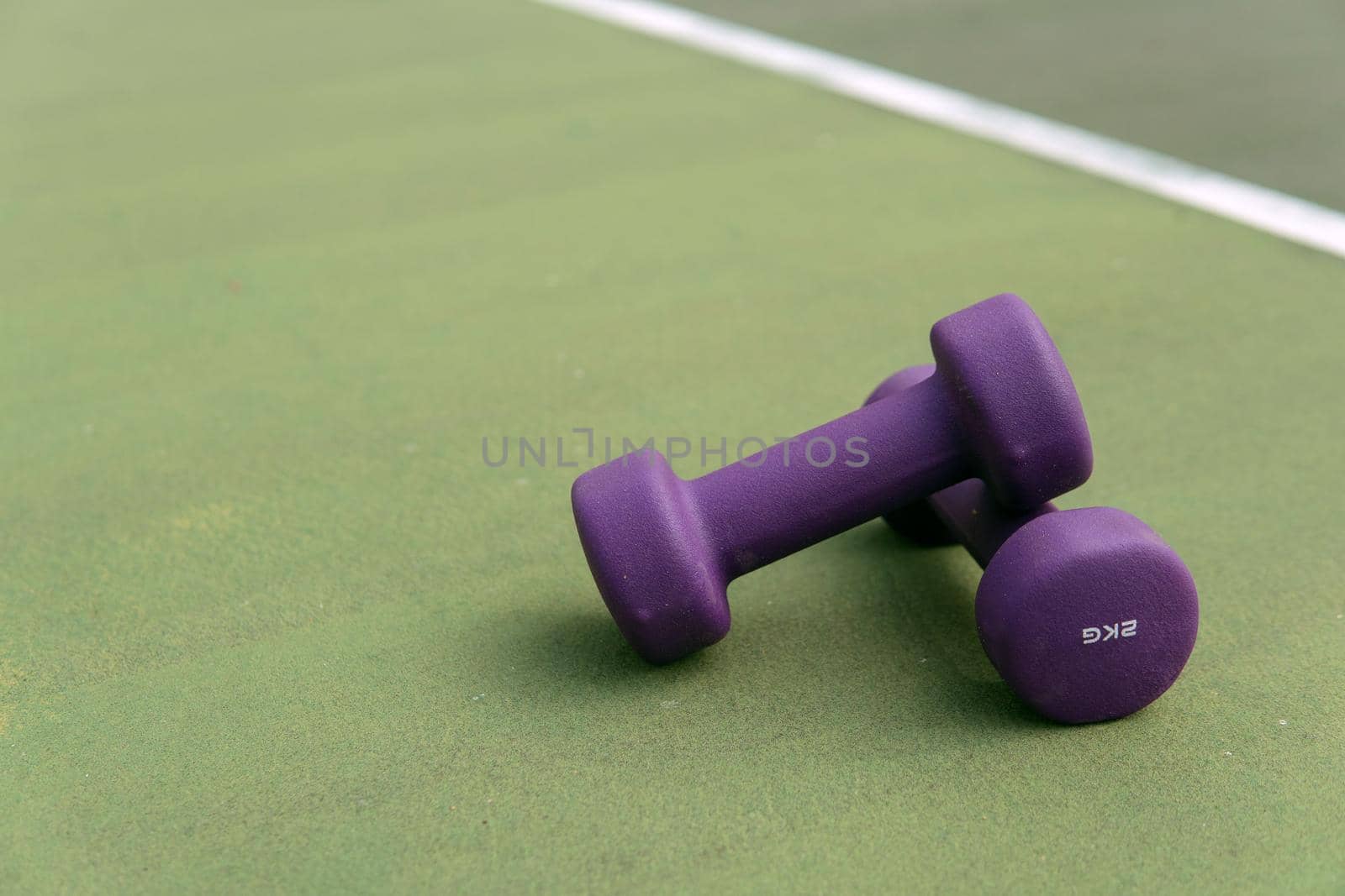 close-up purple dumbbells on the green field. bali