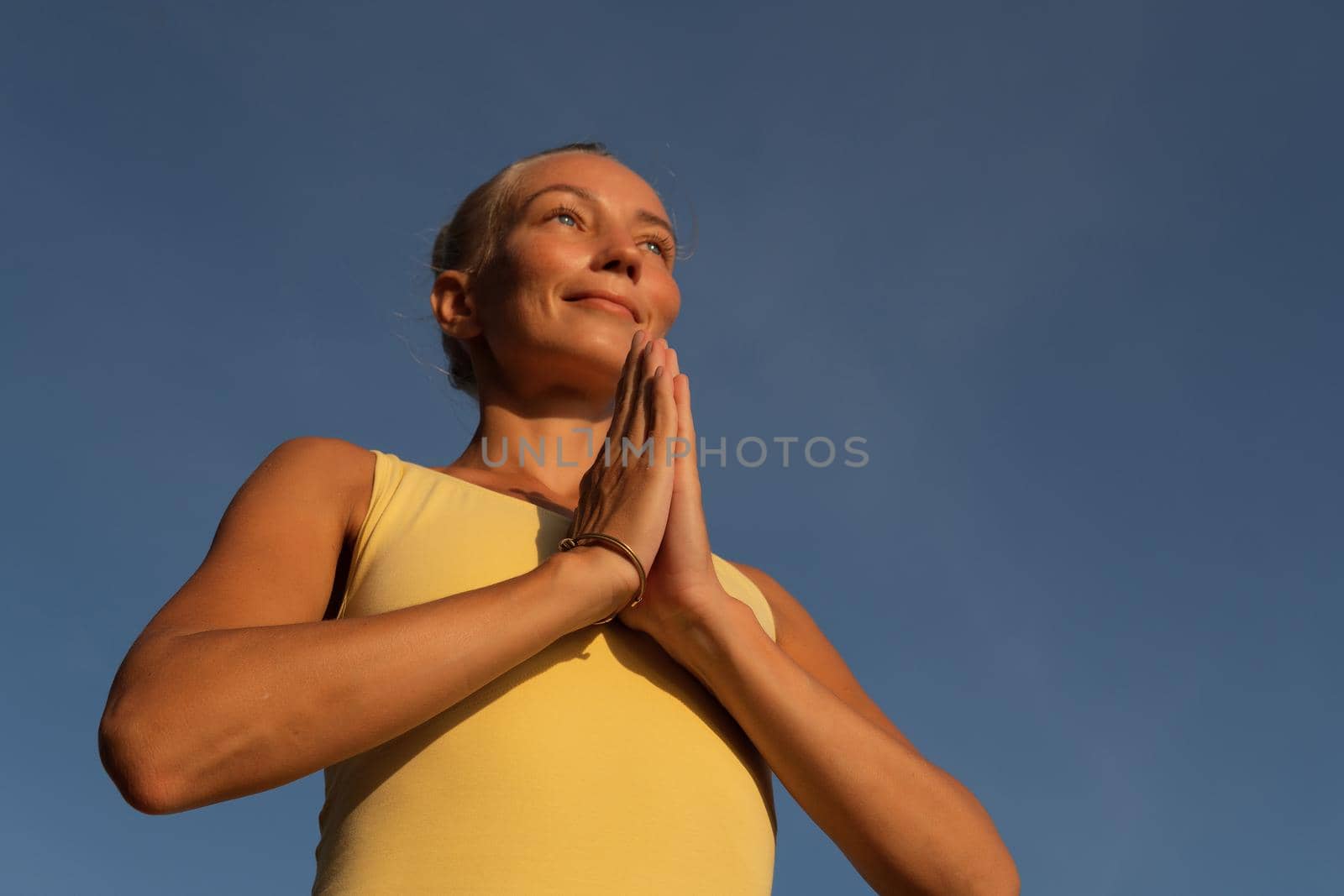 beautiful woman doing yoga on the beach. by Alexzhilkin