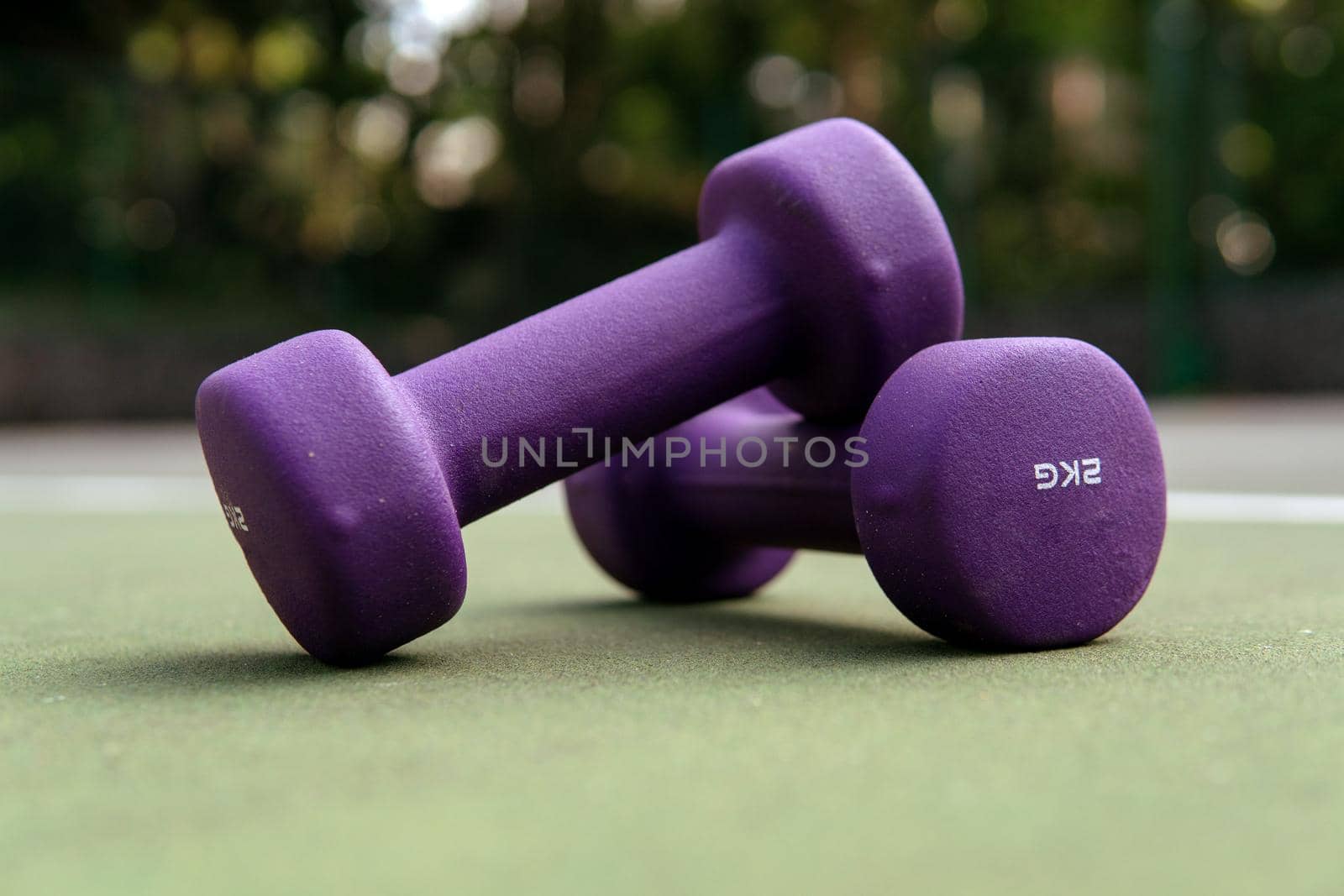 close-up purple dumbbells on the green field. bali