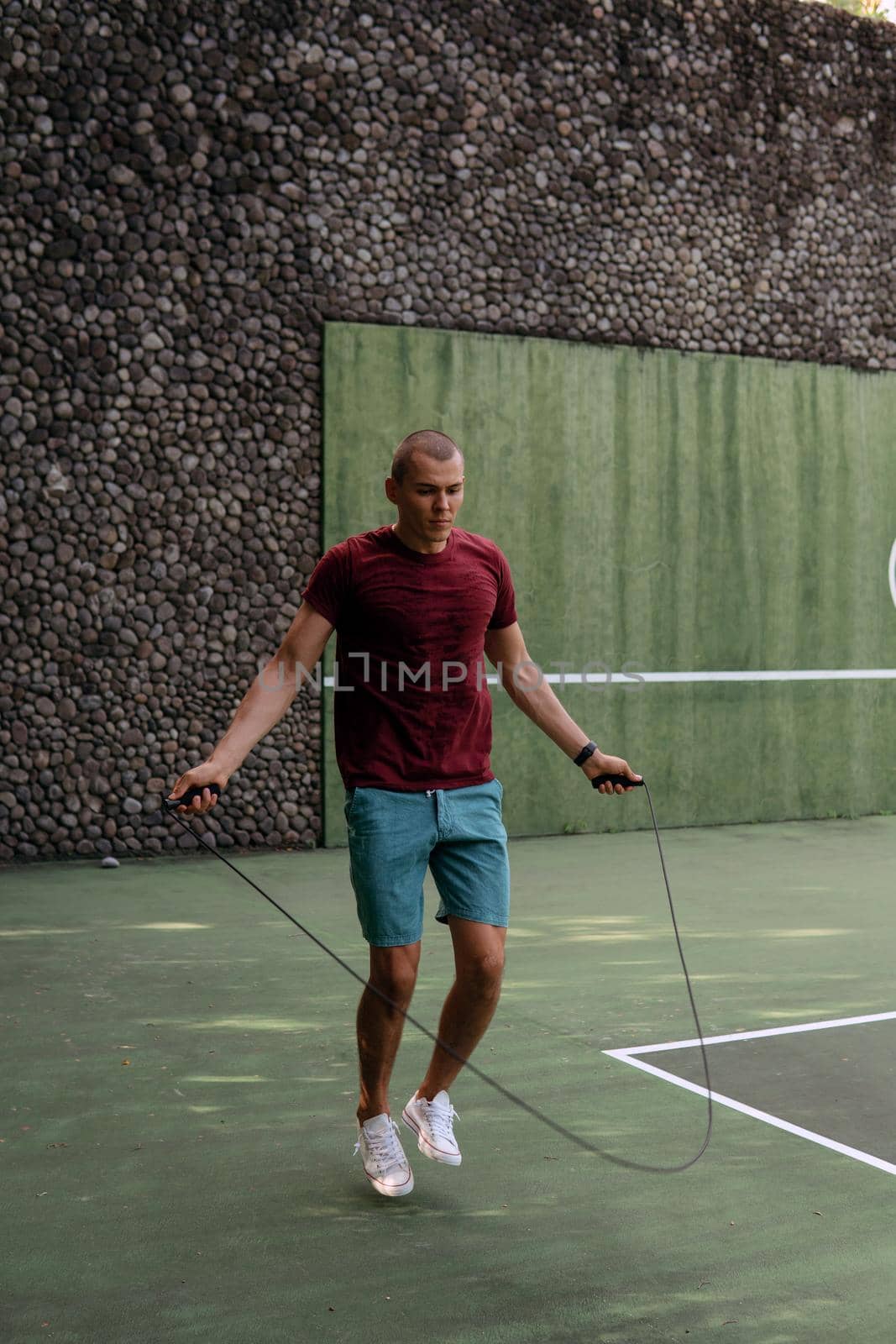 man jumping rope on the tennis court. bali