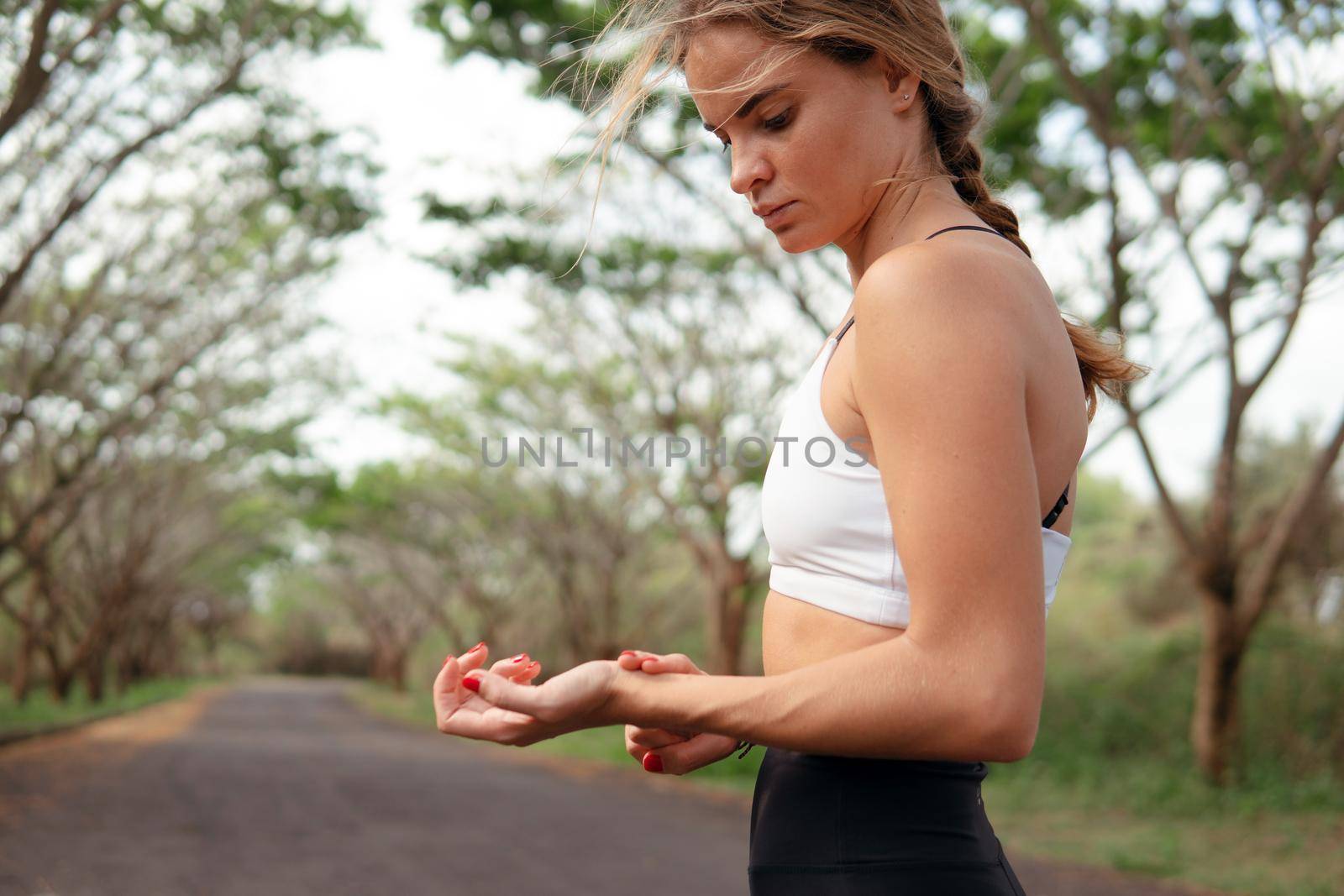 woman in sports wear checking pulse after running.