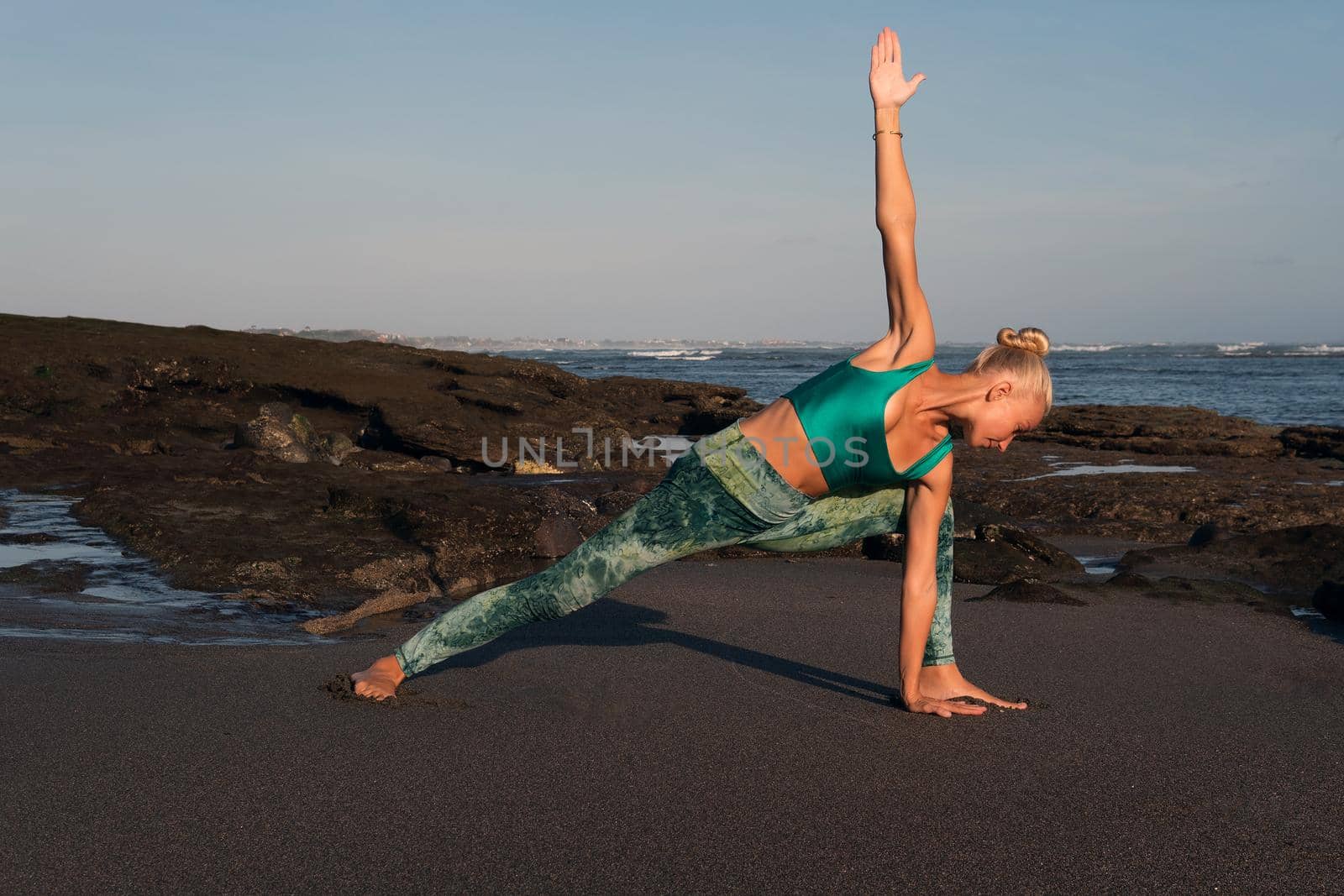 beautiful woman doing yoga on the beach by Alexzhilkin