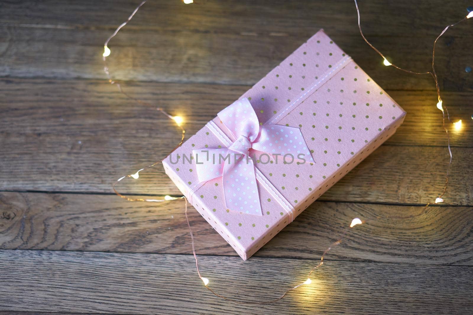 pink gift box garland decoration wooden background holiday. High quality photo