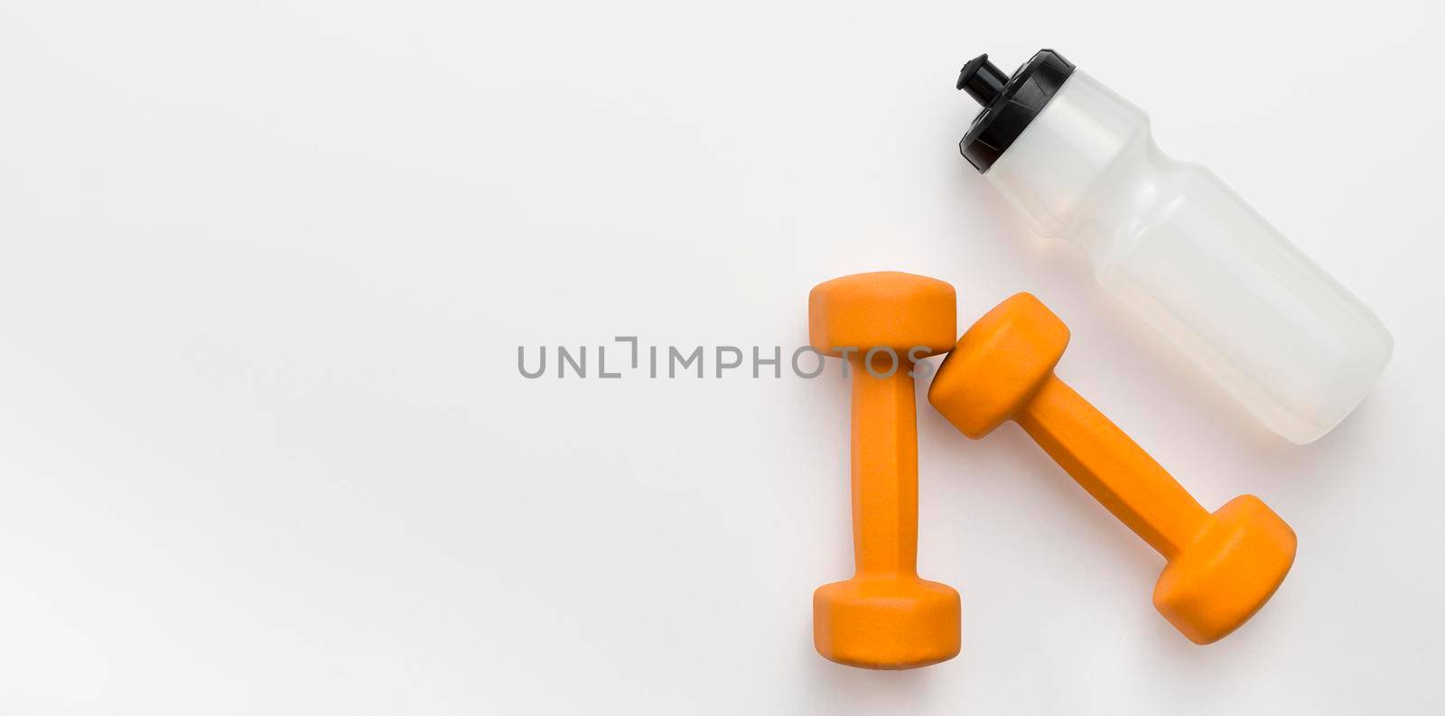 flat lay orange weights with water bottle copy space. High resolution photo