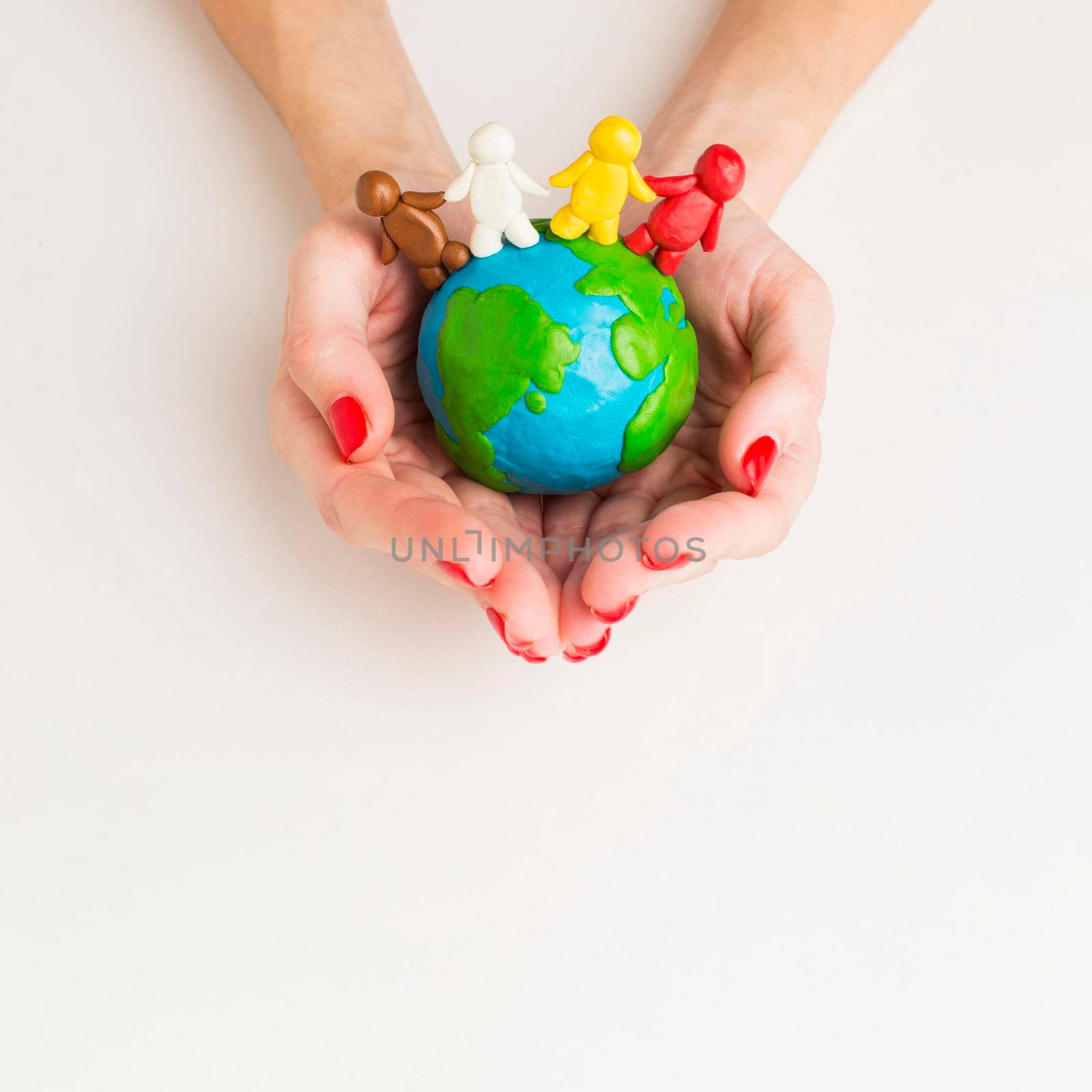 top view hands holding globe with people figurines. High quality photo by Zahard