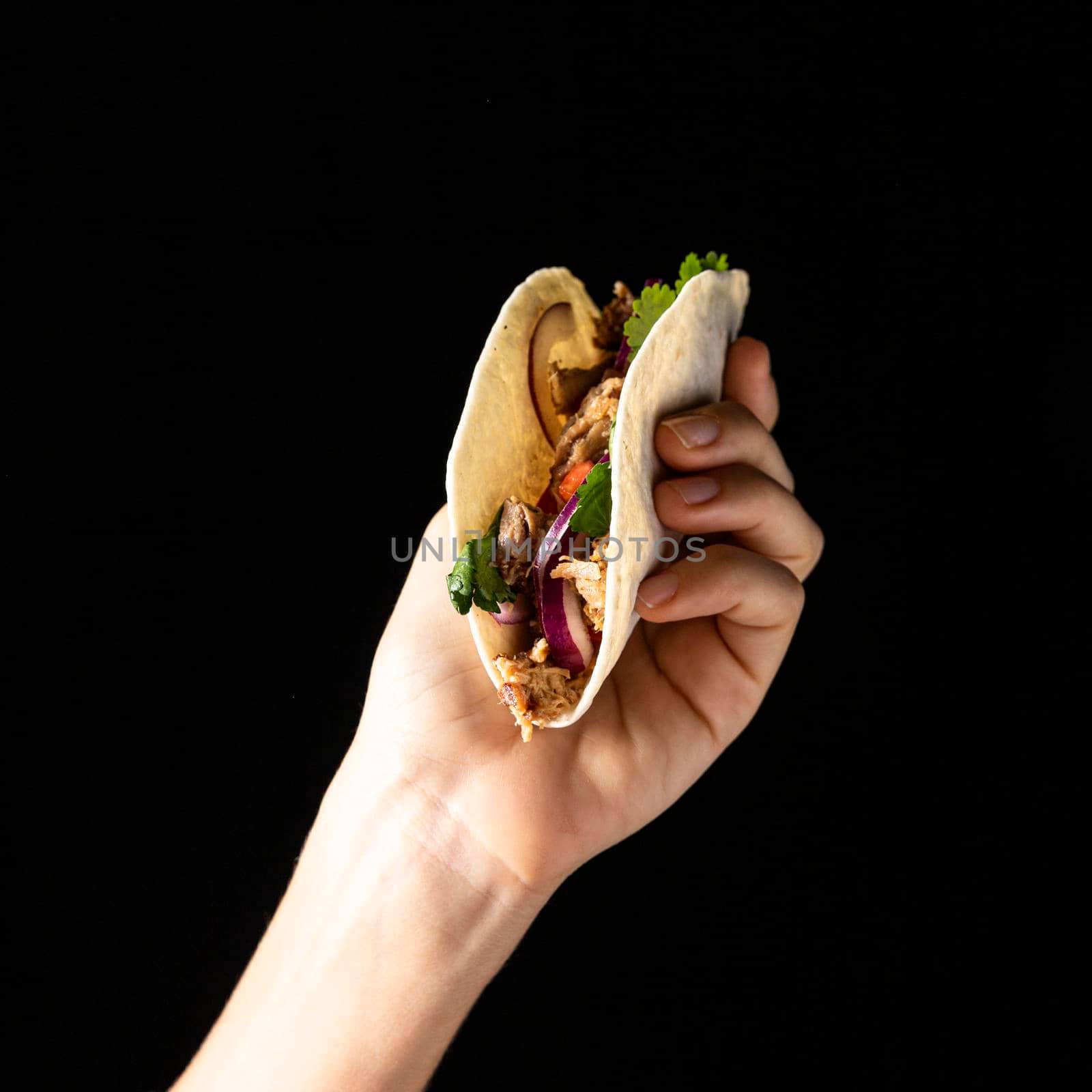 close up hand holding taco with meat. High resolution photo