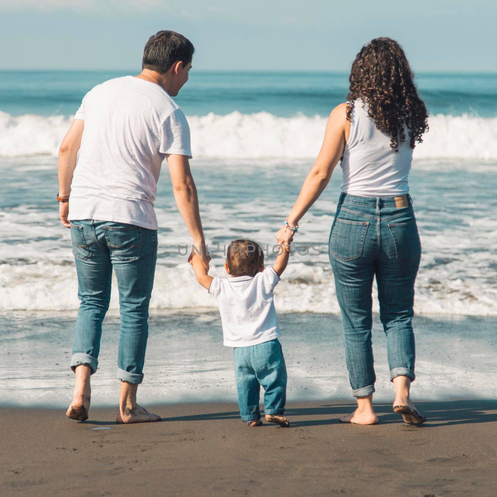 happy family with baby walking beach looking sea. High resolution photo