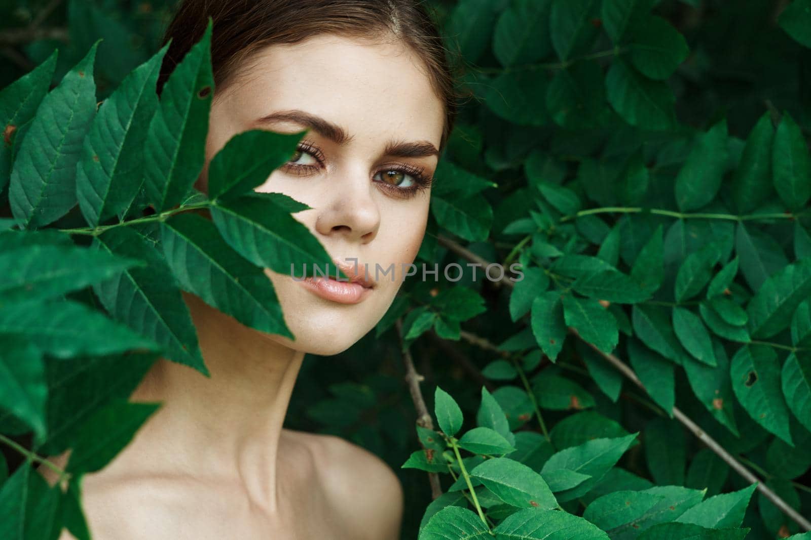 smiling woman green leaves clean skin nature summer close-up. High quality photo