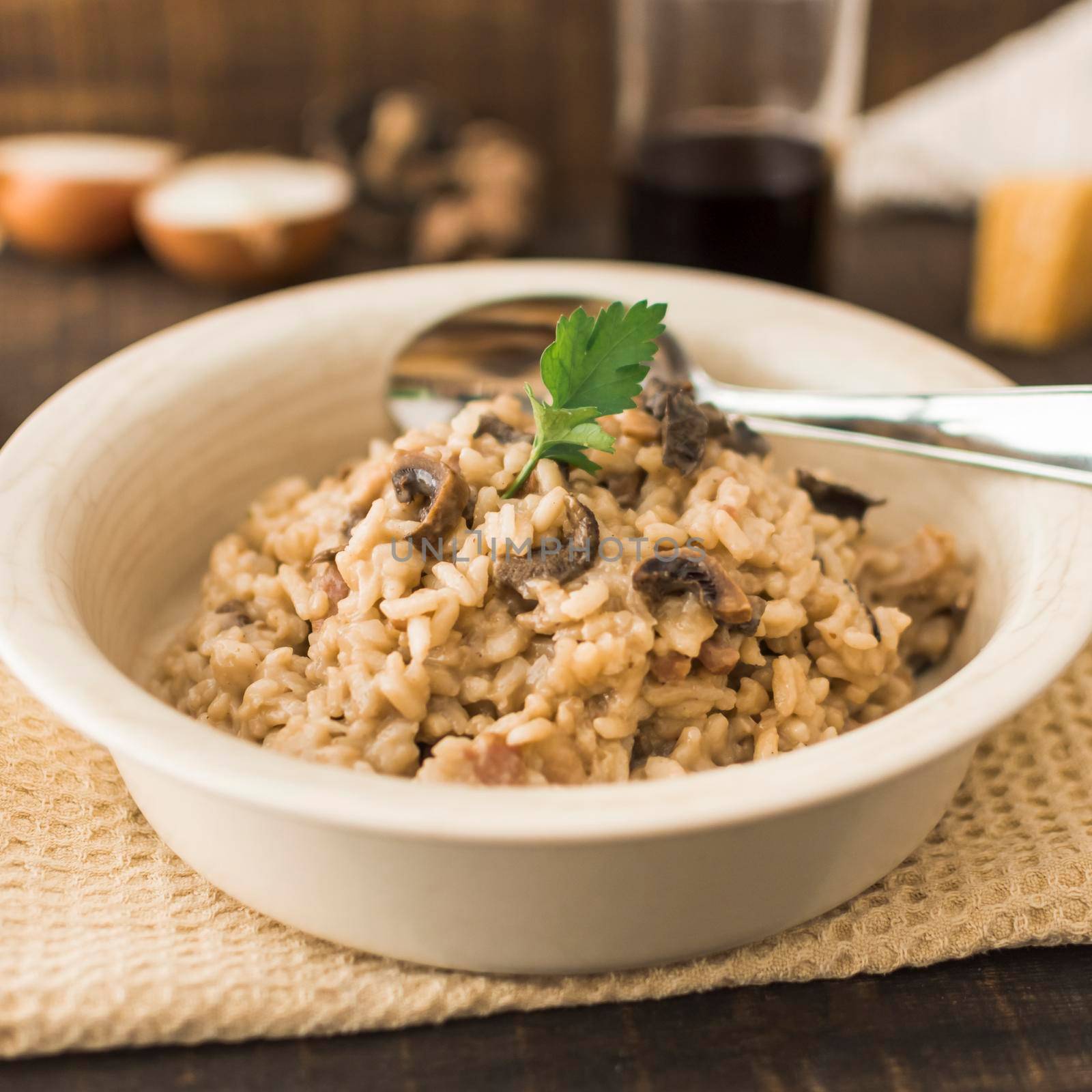 delicious mushroom risotto white bowl with spoon. High resolution photo